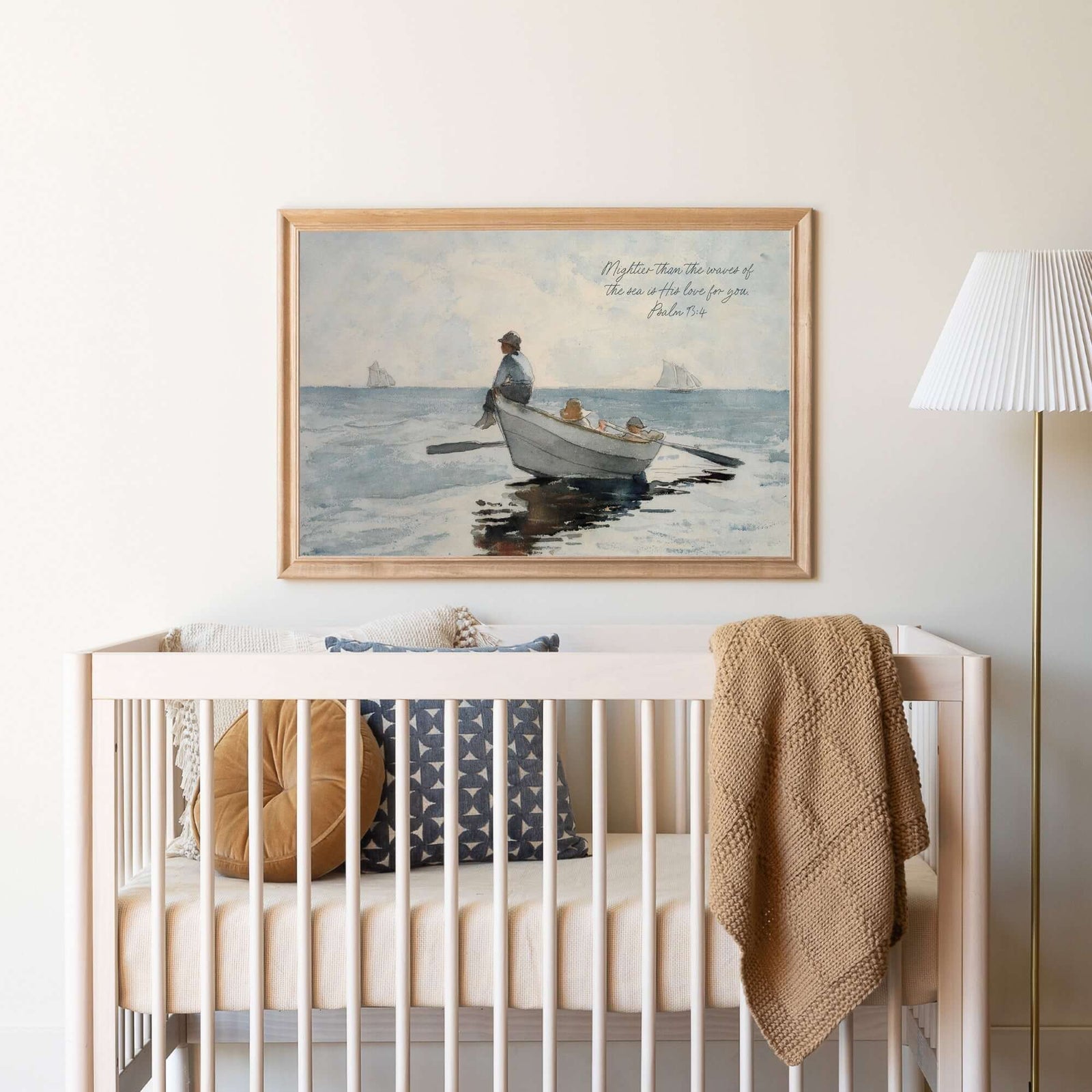 Wooden crib with cozy accents and Bible verse wall art of a fisherman on a serene sea, ideal for faith-inspired nursery decor and art collections.