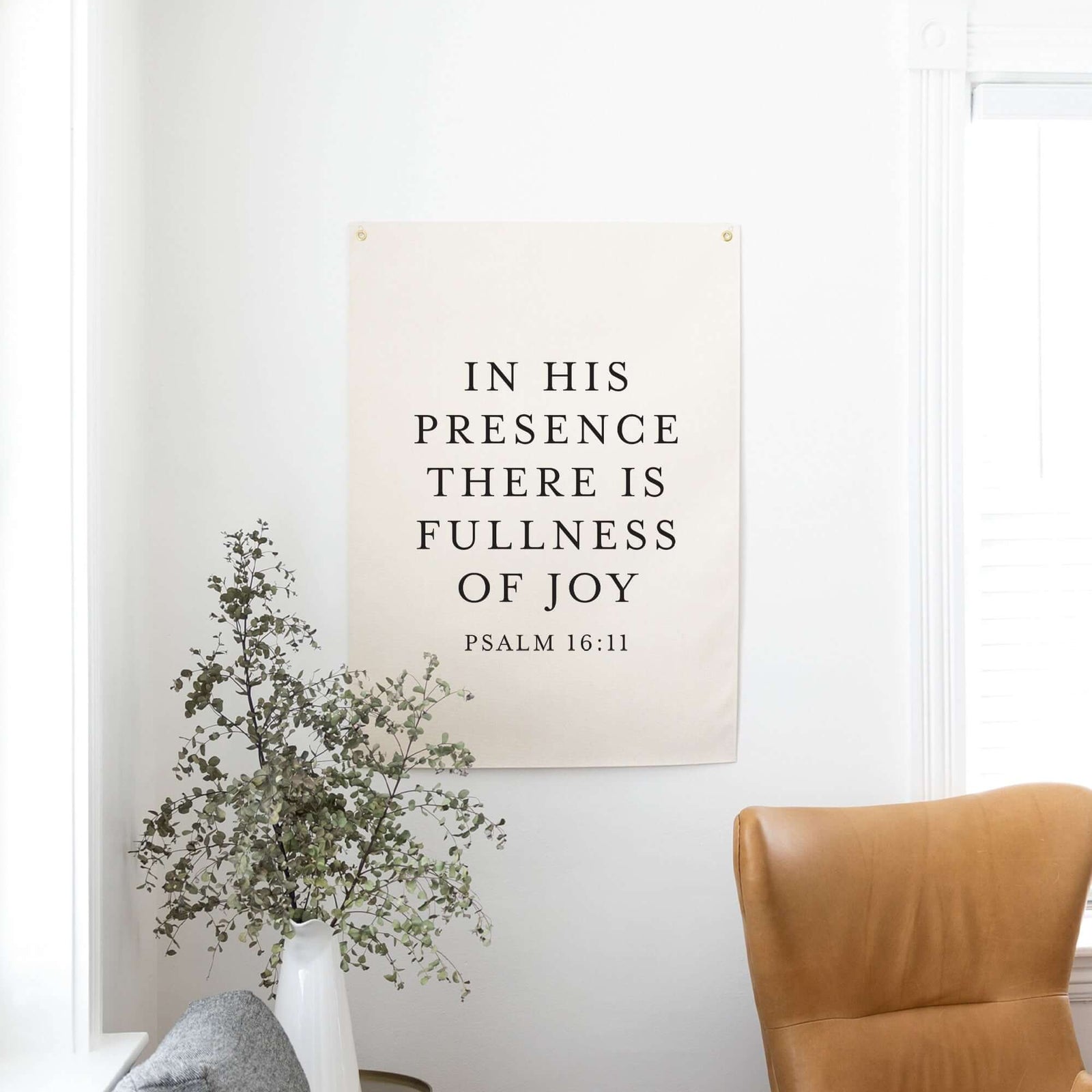 Elegant Psalm 16:11 Scripture wall art with the phrase 'In His presence there is fullness of joy,' displayed in a light and airy space with natural decor elements. Ideal for modern Christian home decor and faith-inspired interiors.
