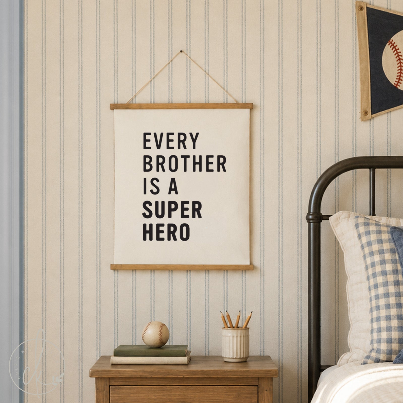 Canvas sign with the text "Every Brother is a Superhero" hanging on a white wall. Below the sign is a wooden chest with a baseball glove and books on top