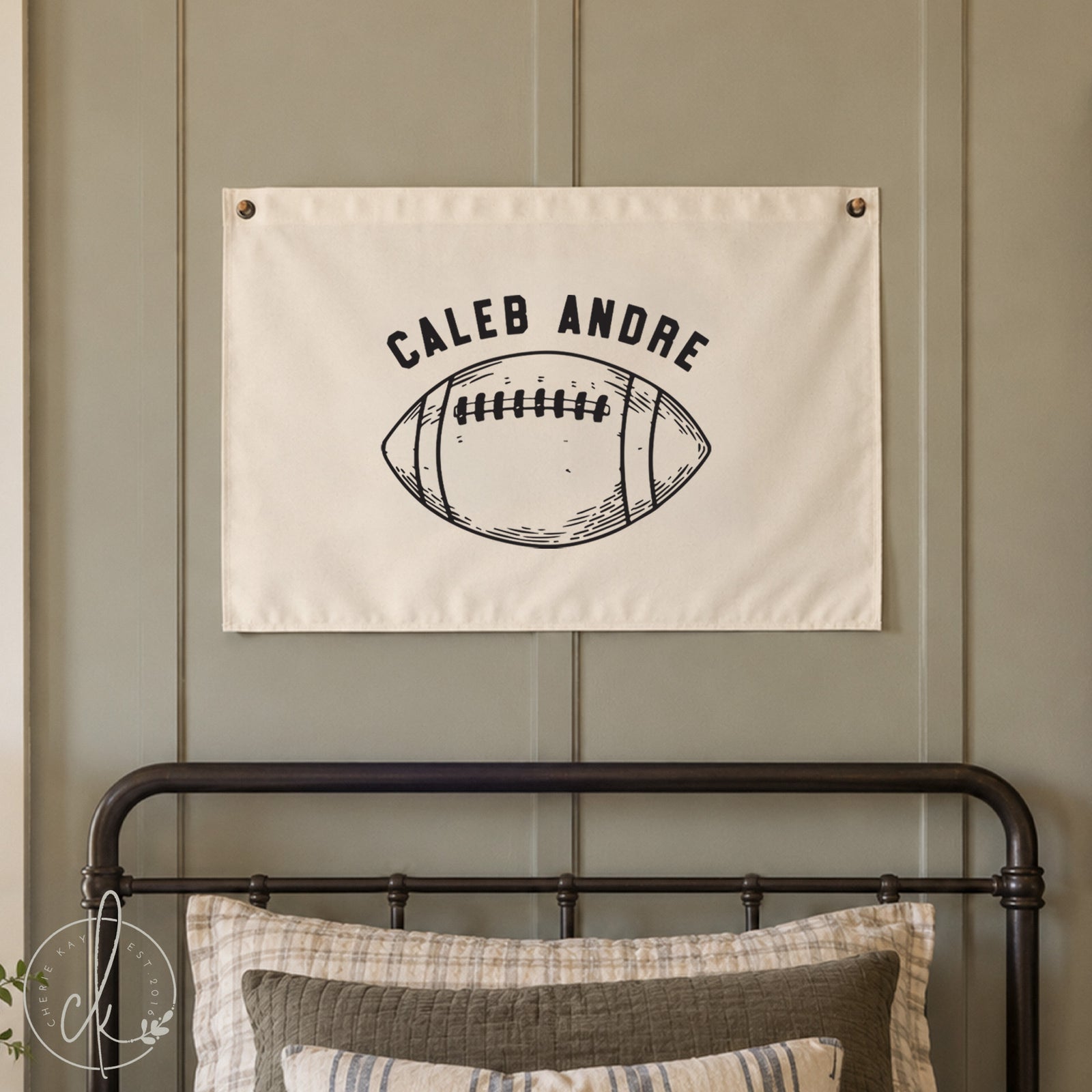 Canvas wall banner with custom name and football hanging over little boys bed in a sports themed room. 