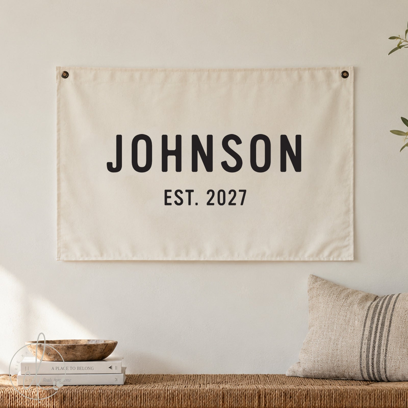 Personalized family name canvas sign, displayed on a rustic brick wall with greenery. Custom established date wall decor, perfect for anniversary, wedding, housewarming, or family gift.