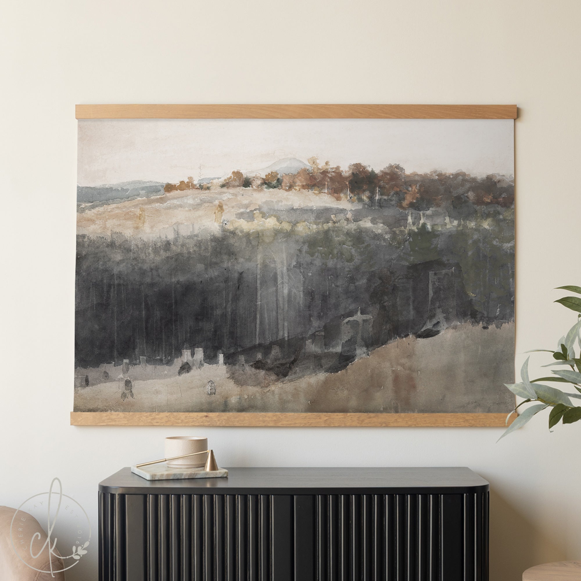Framed landscape painting on a wall above a black cabinet.