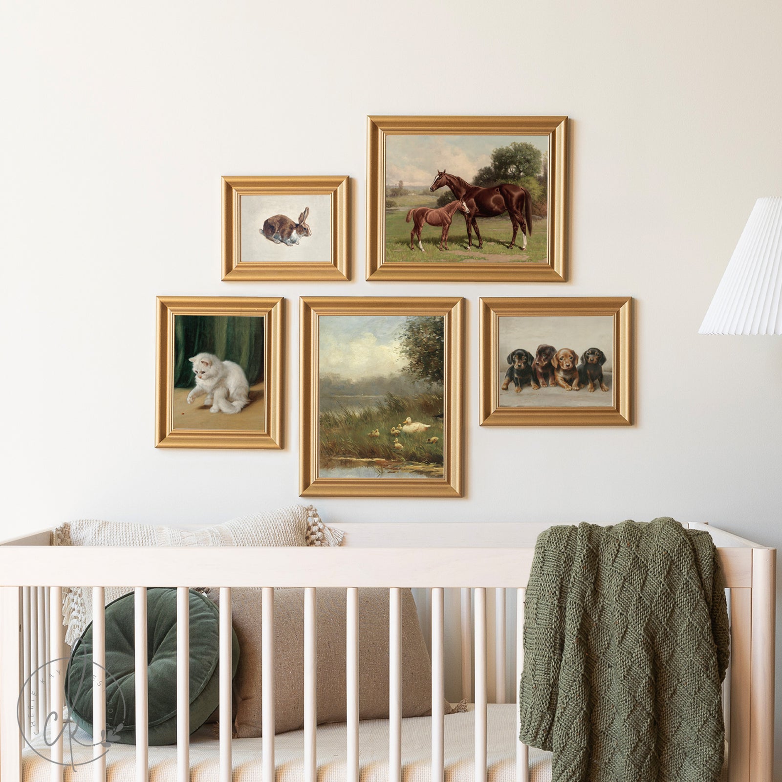 Framed animal prints on a wall above a crib with a green blanket and pillow.