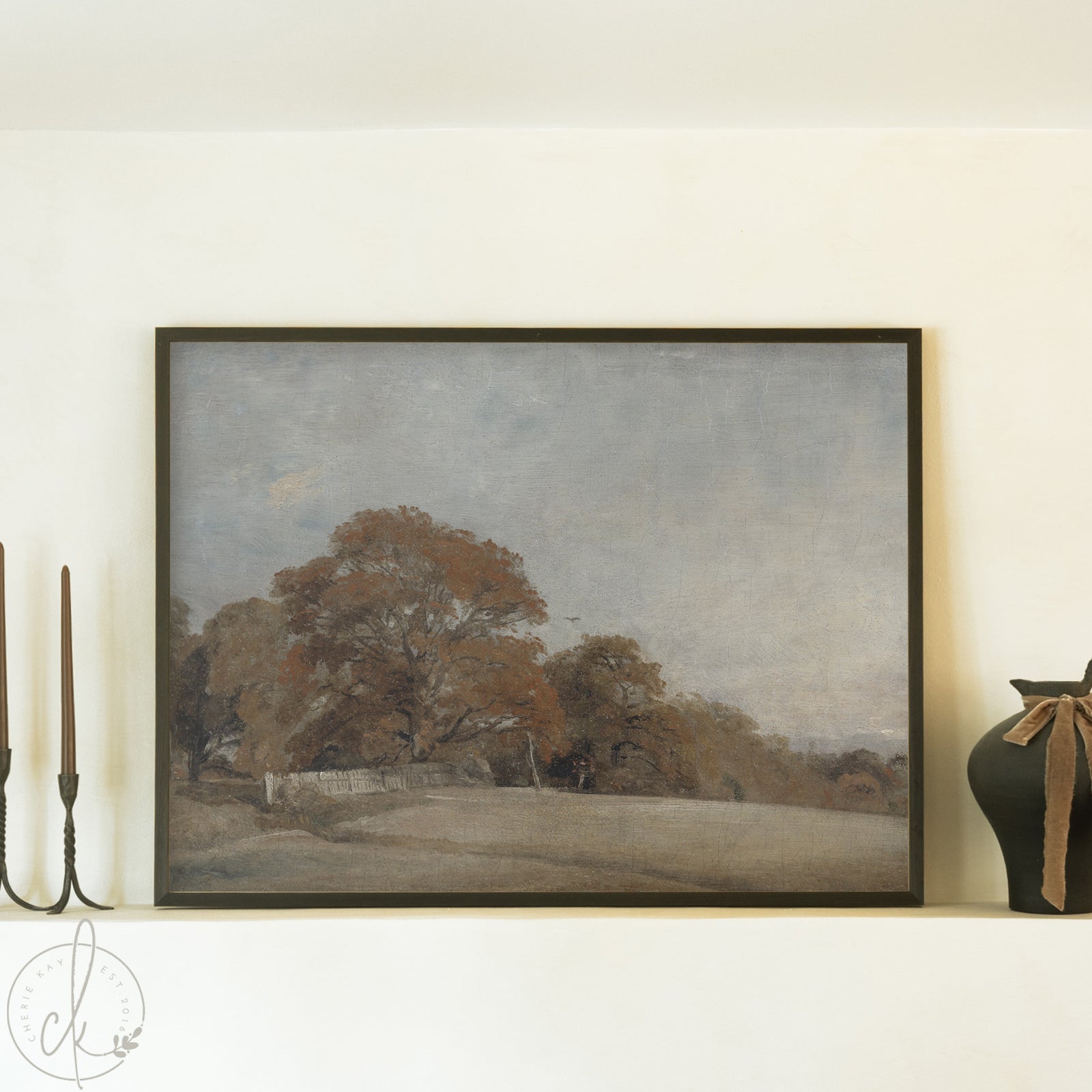 Framed landscape painting on a wall with decorative elements.