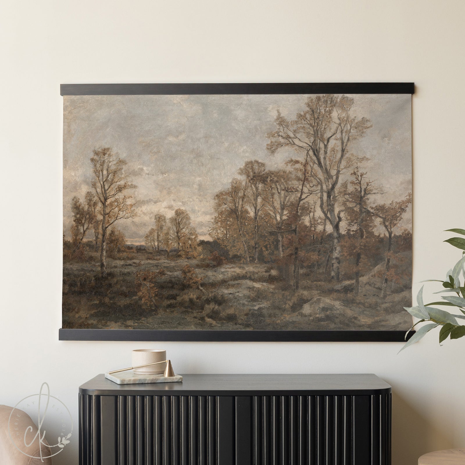 Wall-mounted landscape painting in a room with a black cabinet and plant.