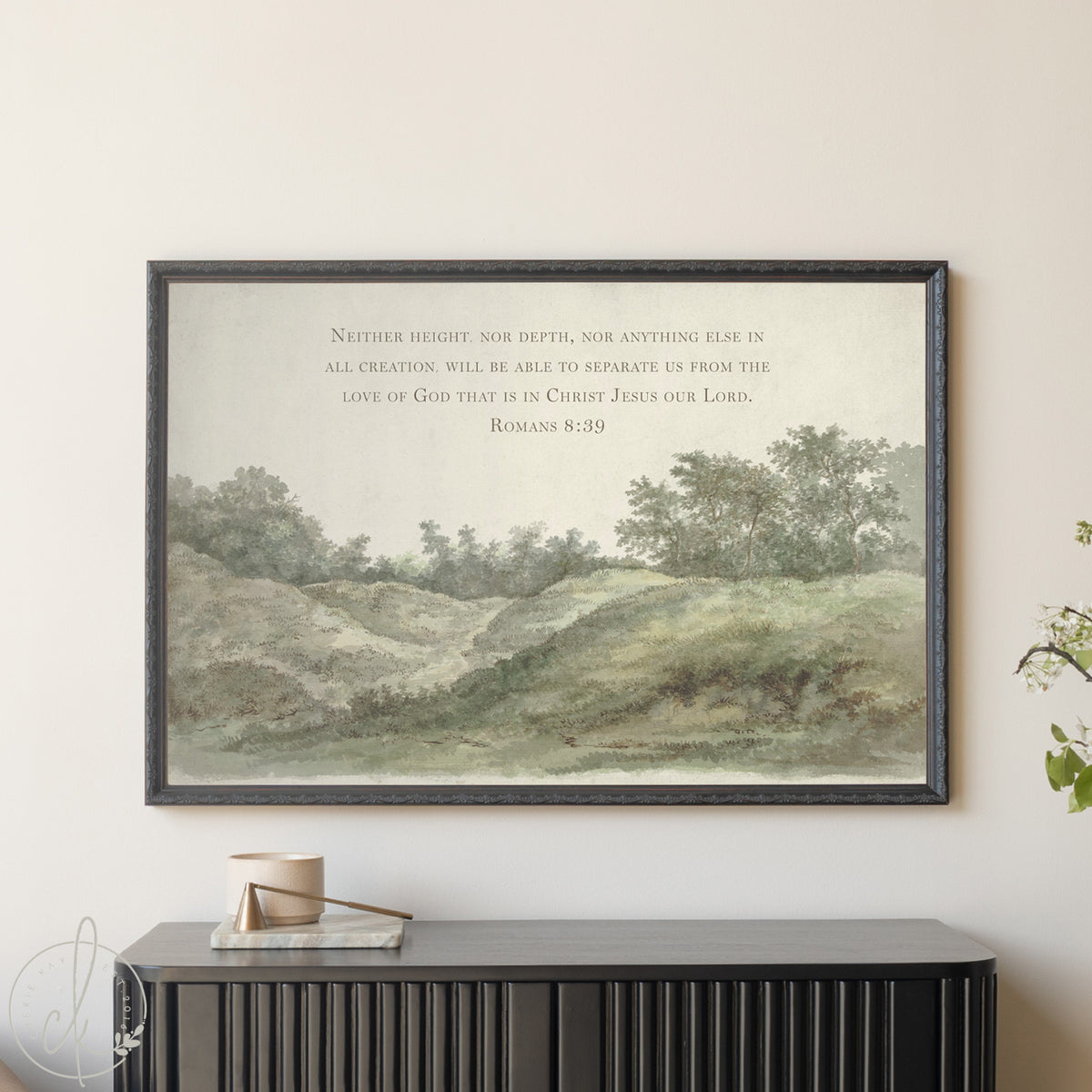 Framed landscape print with text on a wall above a black console table.