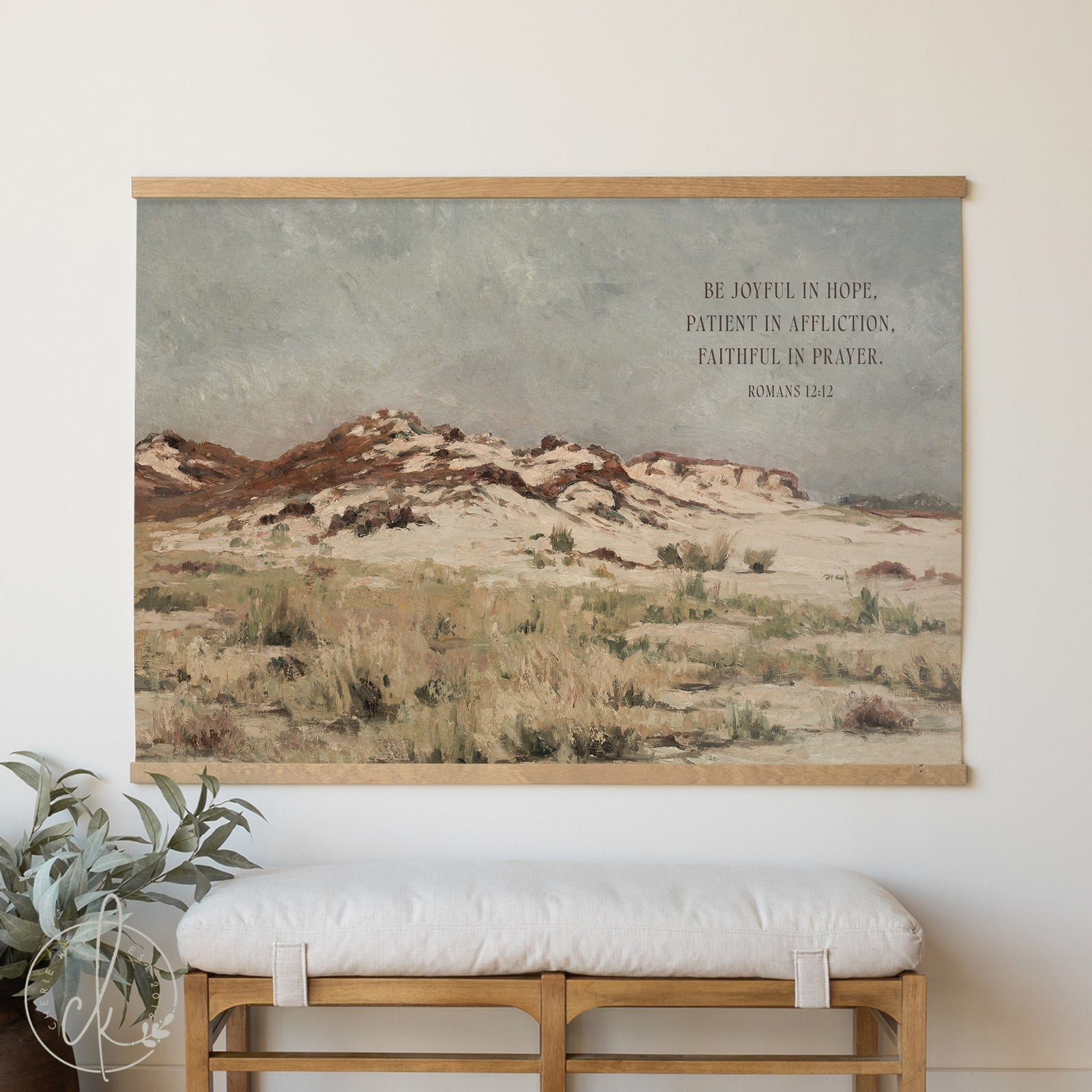Framed desert landscape print with motivational quote on a wall above a bench.