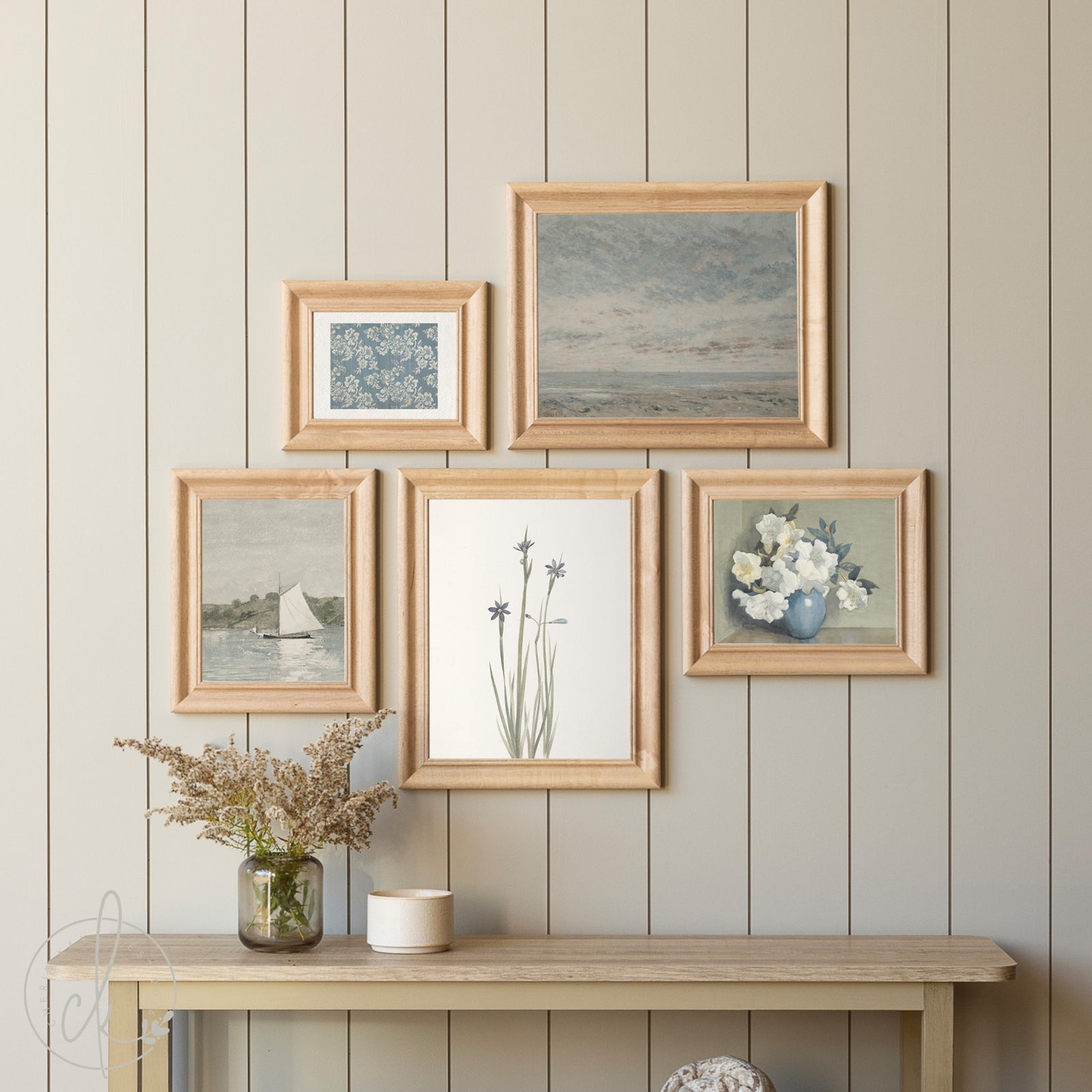 Set of framed artworks on a wall with a wooden console table below.