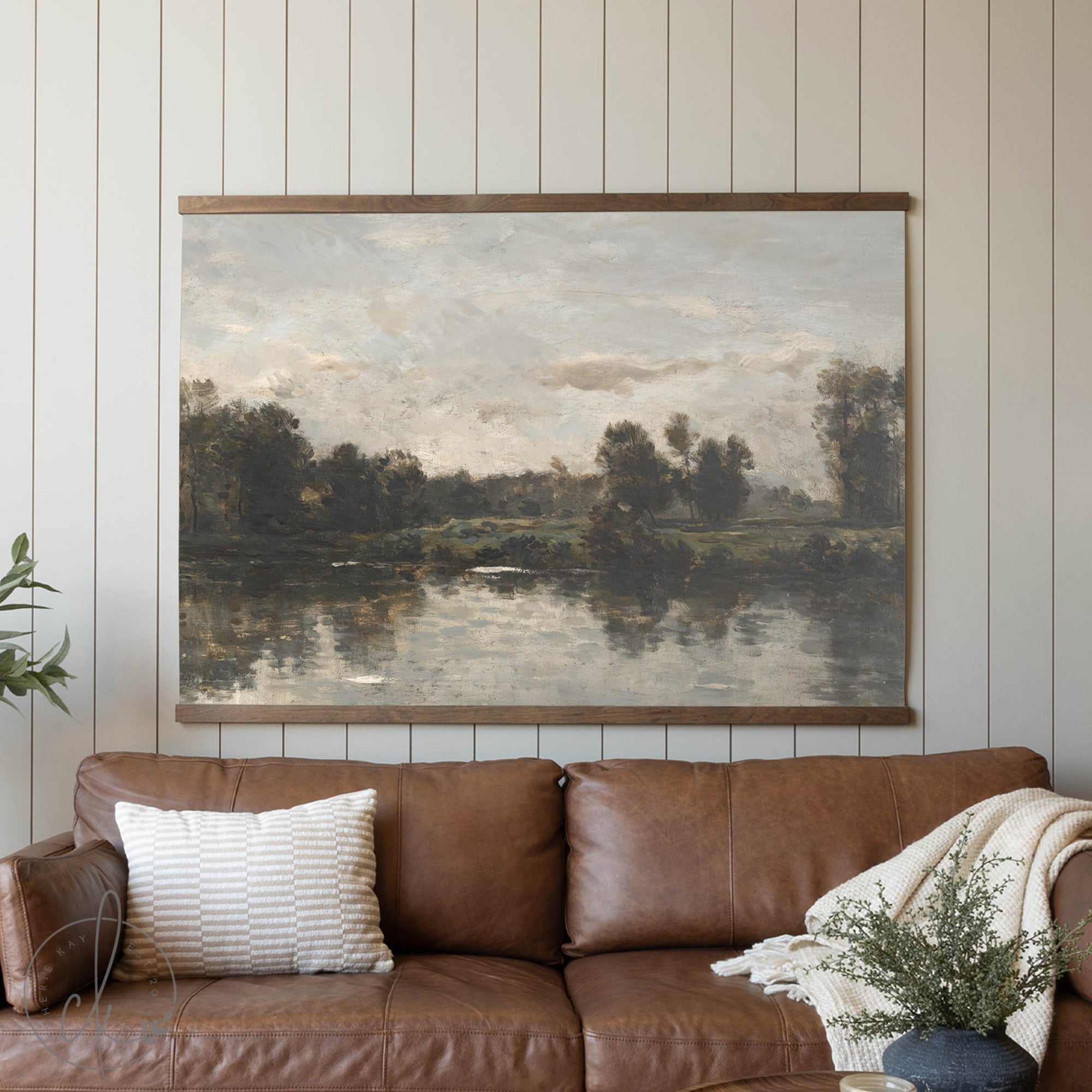 Living room with a brown leather sofa and a large landscape painting on the wall.