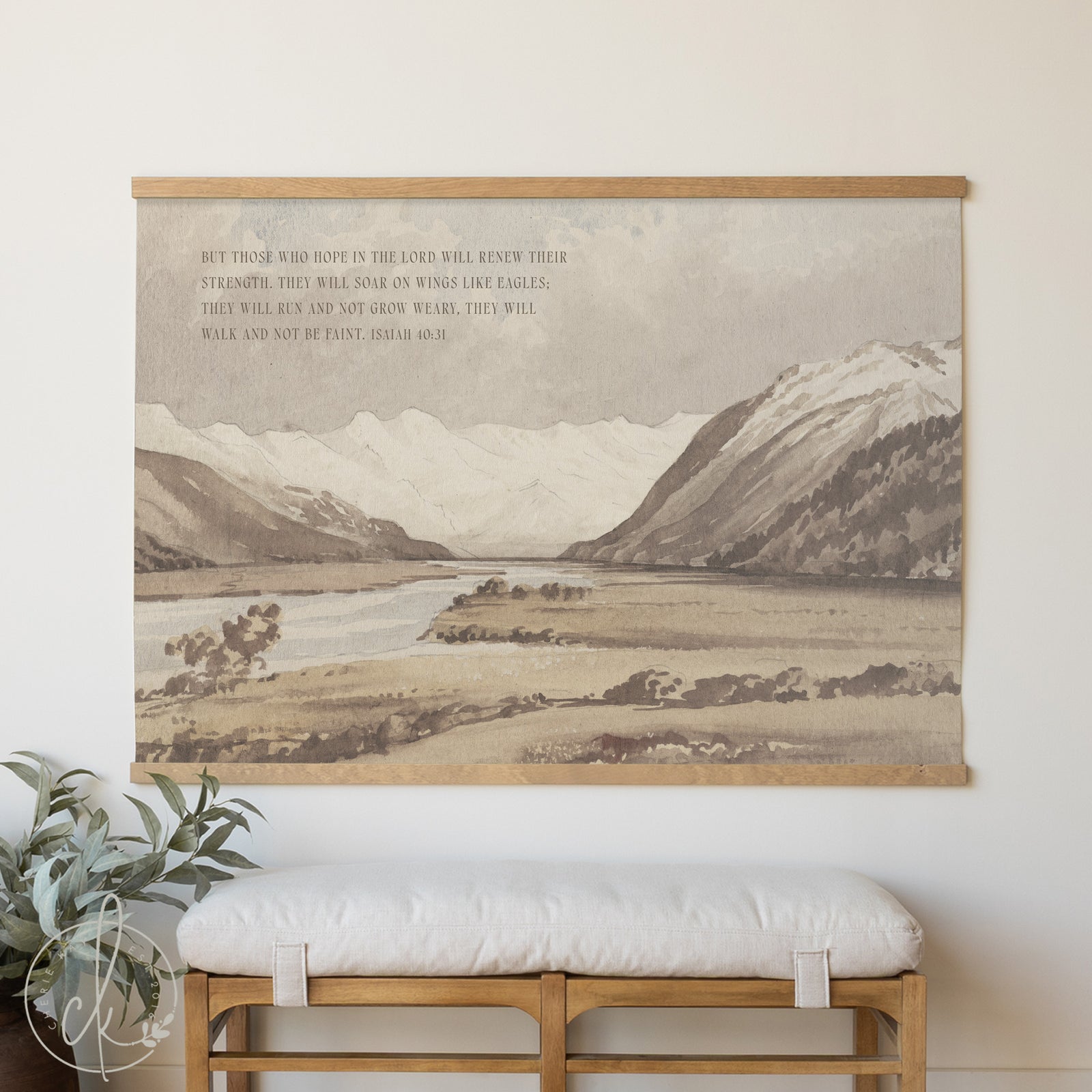 Decorative wall hanging with mountain landscape and text above a bench.