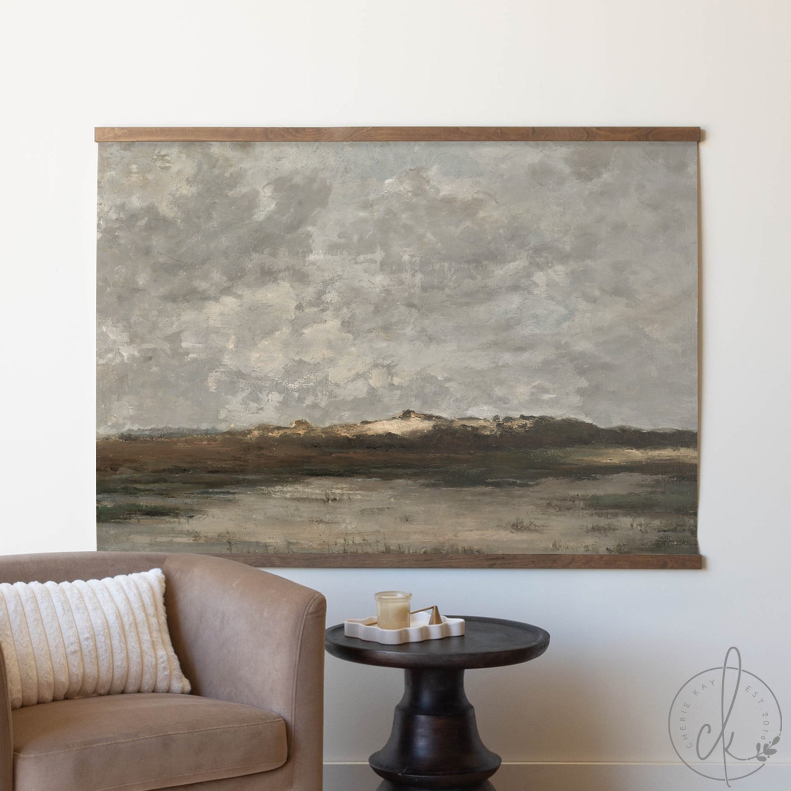 Abstract landscape painting on a wall above a sofa and side table.