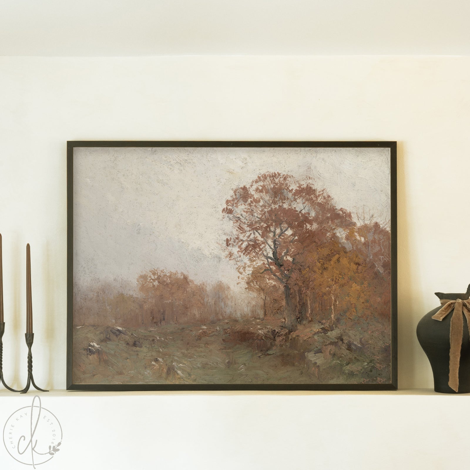 Framed landscape painting of a tree in an autumn setting on a wall.