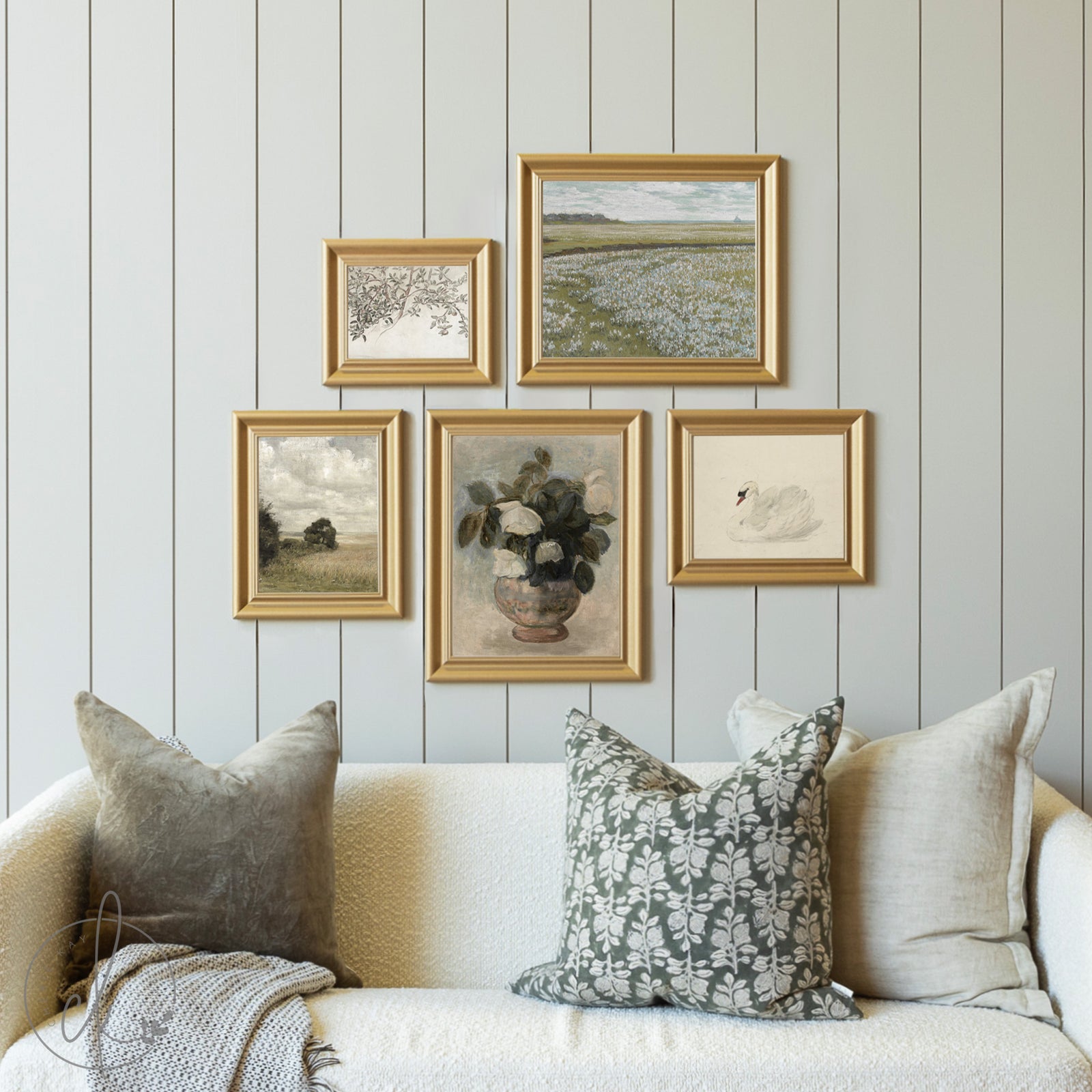 Decorative wall with framed artwork and a sofa with pillows