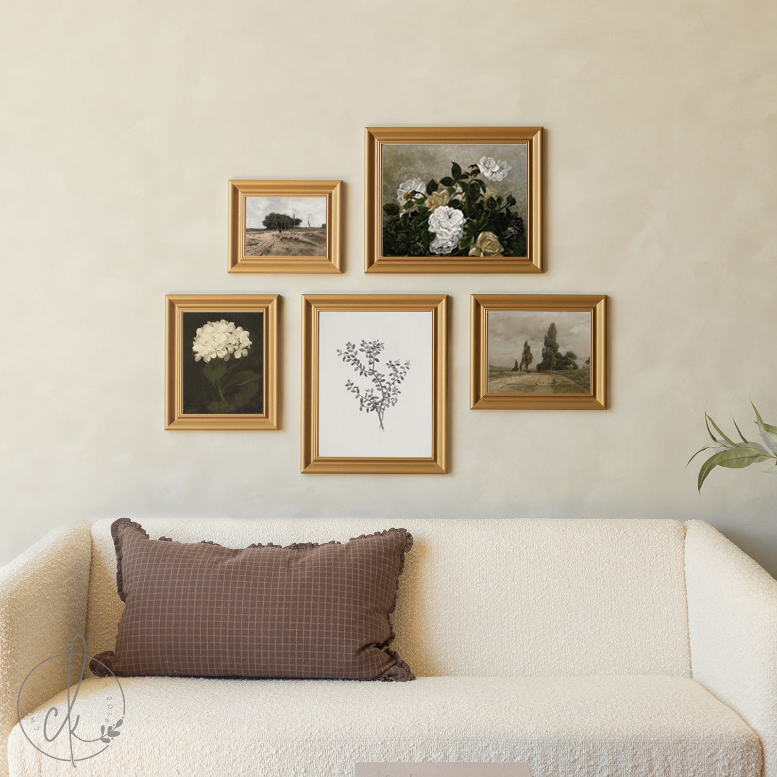 Framed artwork on a wall above a sofa with a brown pillow.