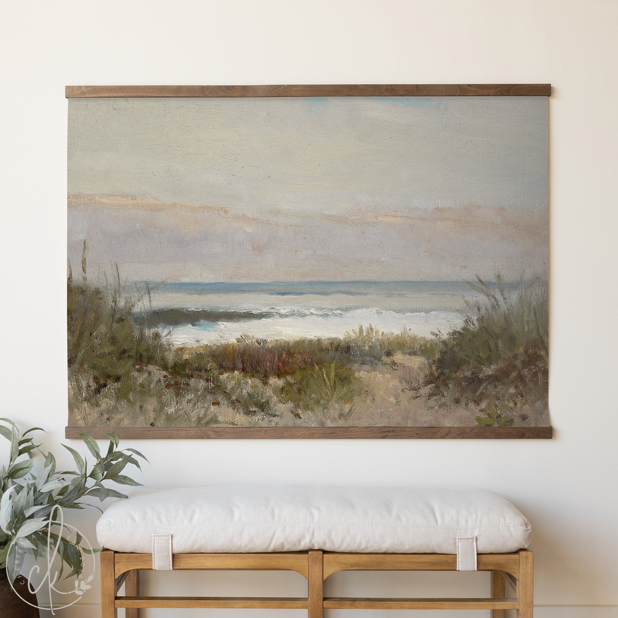Framed beach landscape painting above a white cushioned bench.