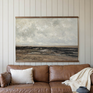 Brown leather sofa with a textured wall art piece in a room with wooden paneling.
