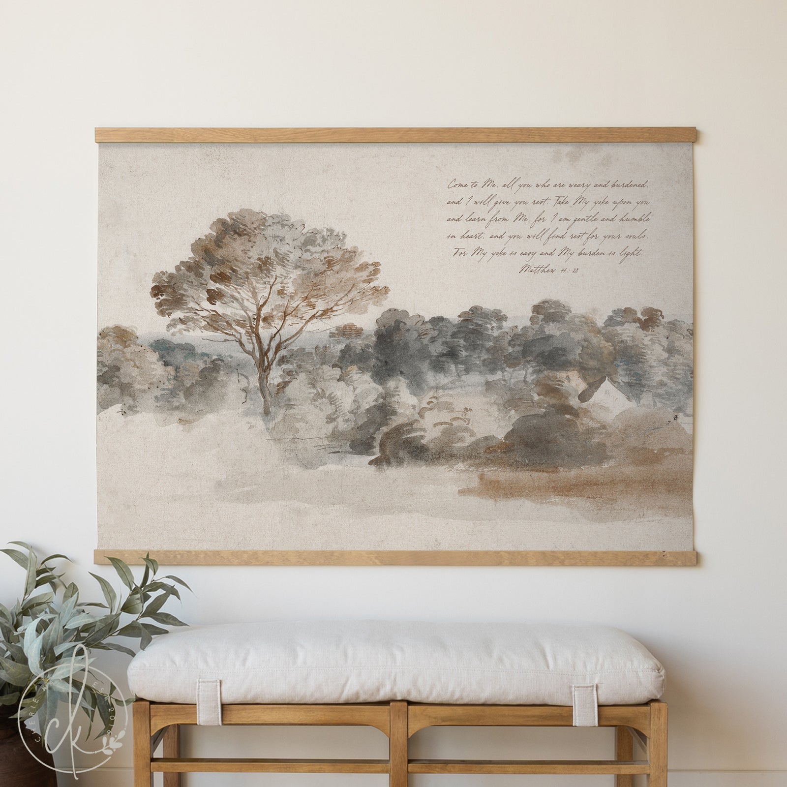 Framed landscape print with trees and text on a wall above a wooden bench.