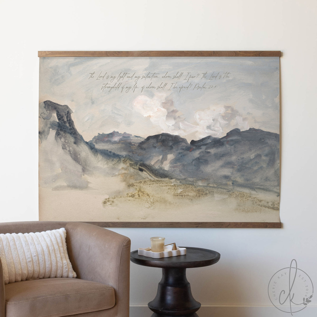 Large landscape painting on a wall above a sofa and side table.