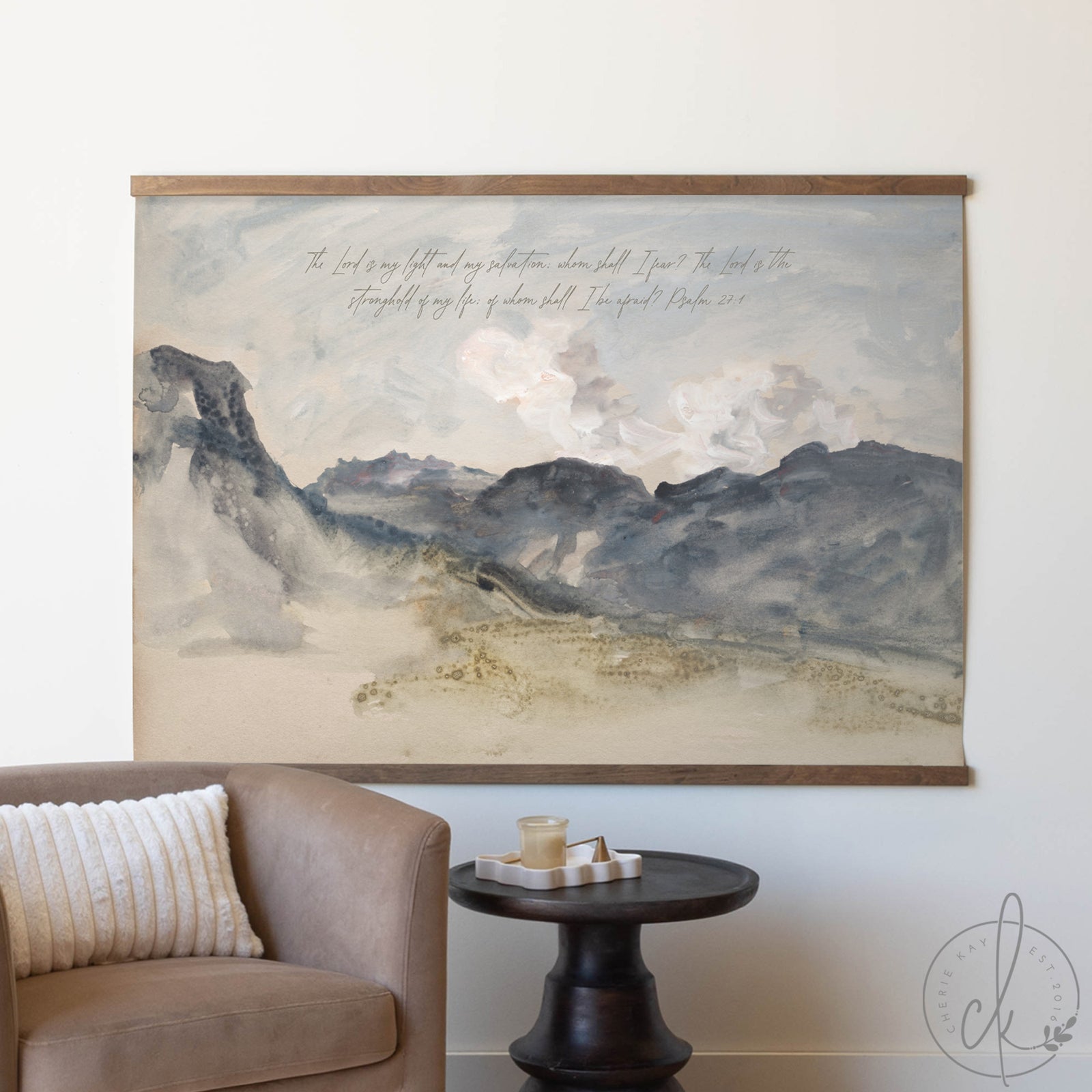 Large landscape painting on a wall above a sofa and side table.