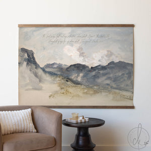 Large landscape painting on a wall above a sofa and side table.