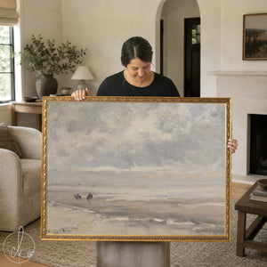 Framed vintage coastal art with beach landscape and muted ocean tones.