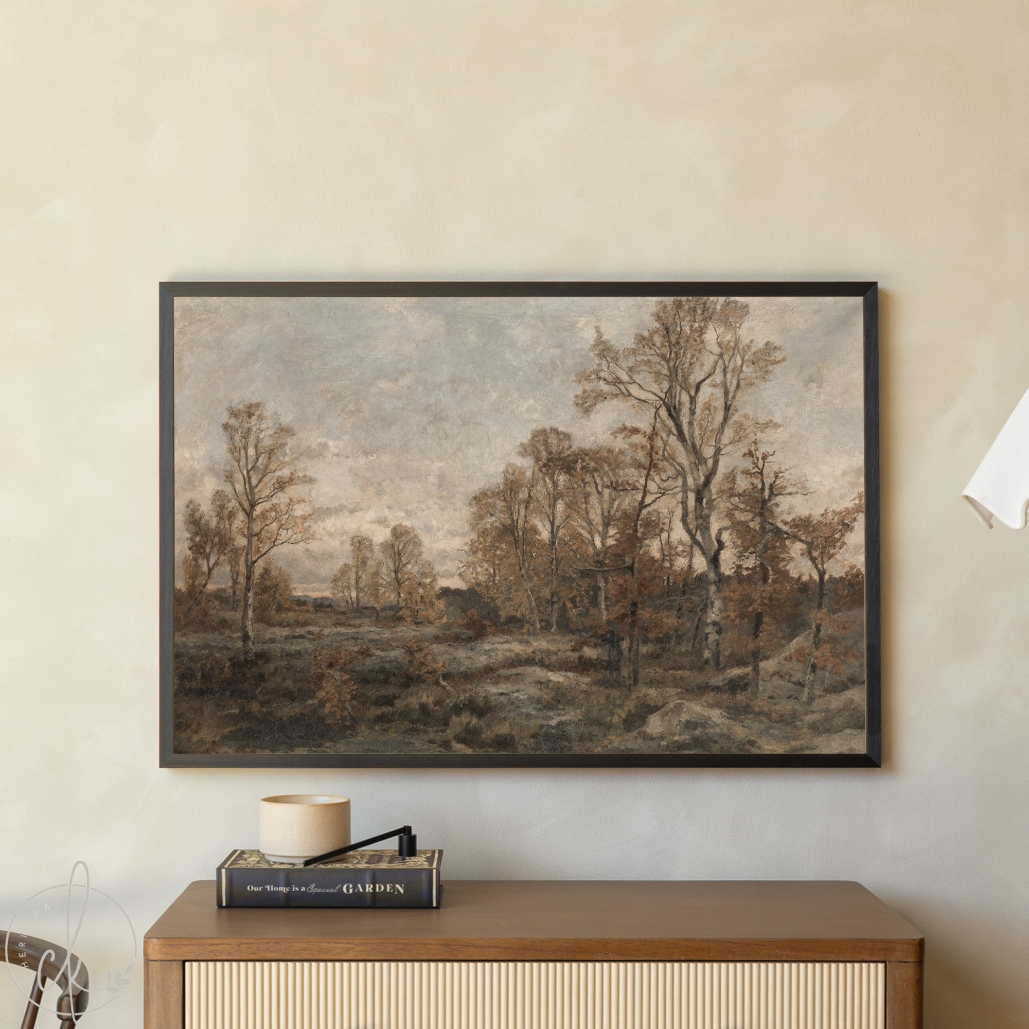 Framed landscape painting on a wall above a wooden cabinet.