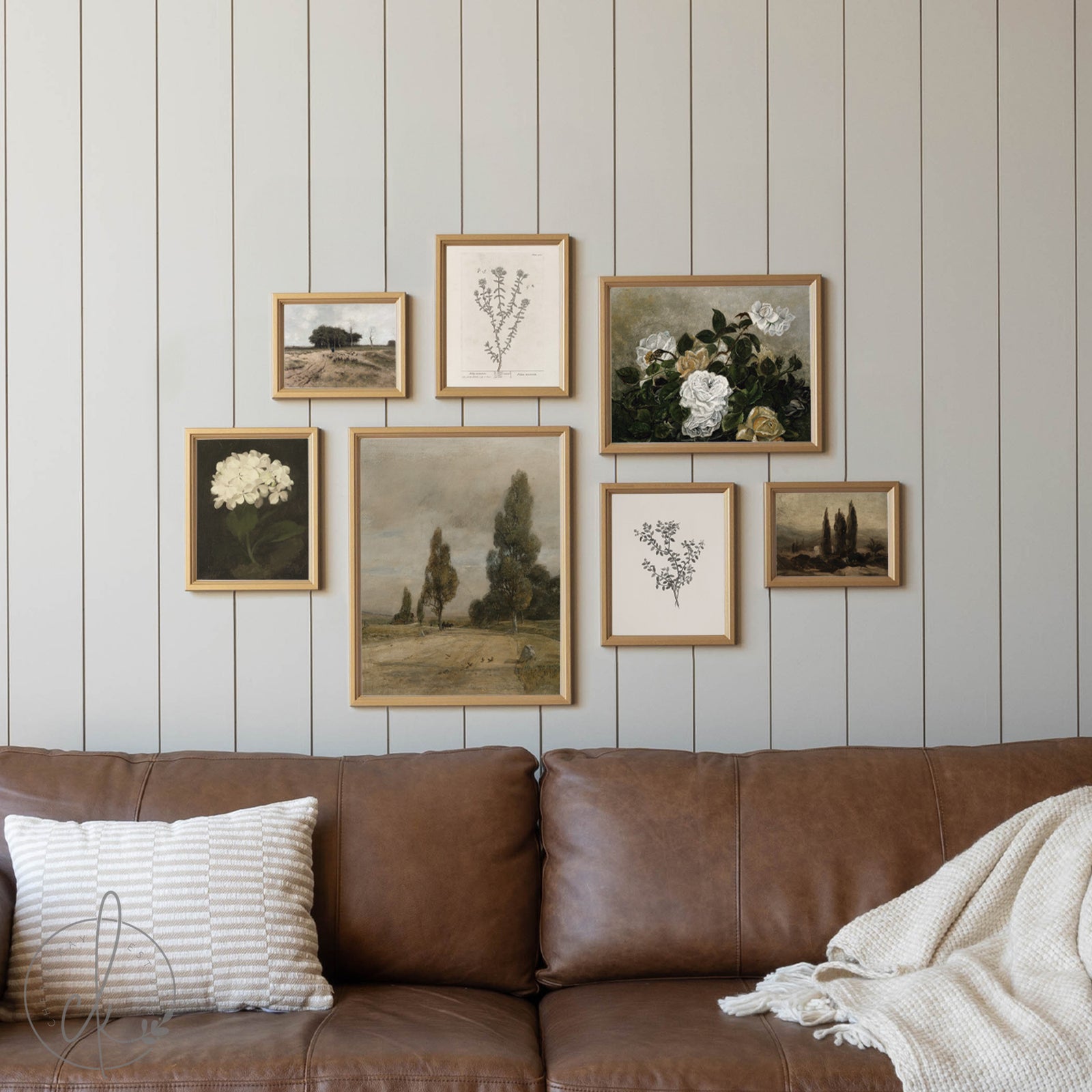 Wall with framed botanical prints above a brown sofa