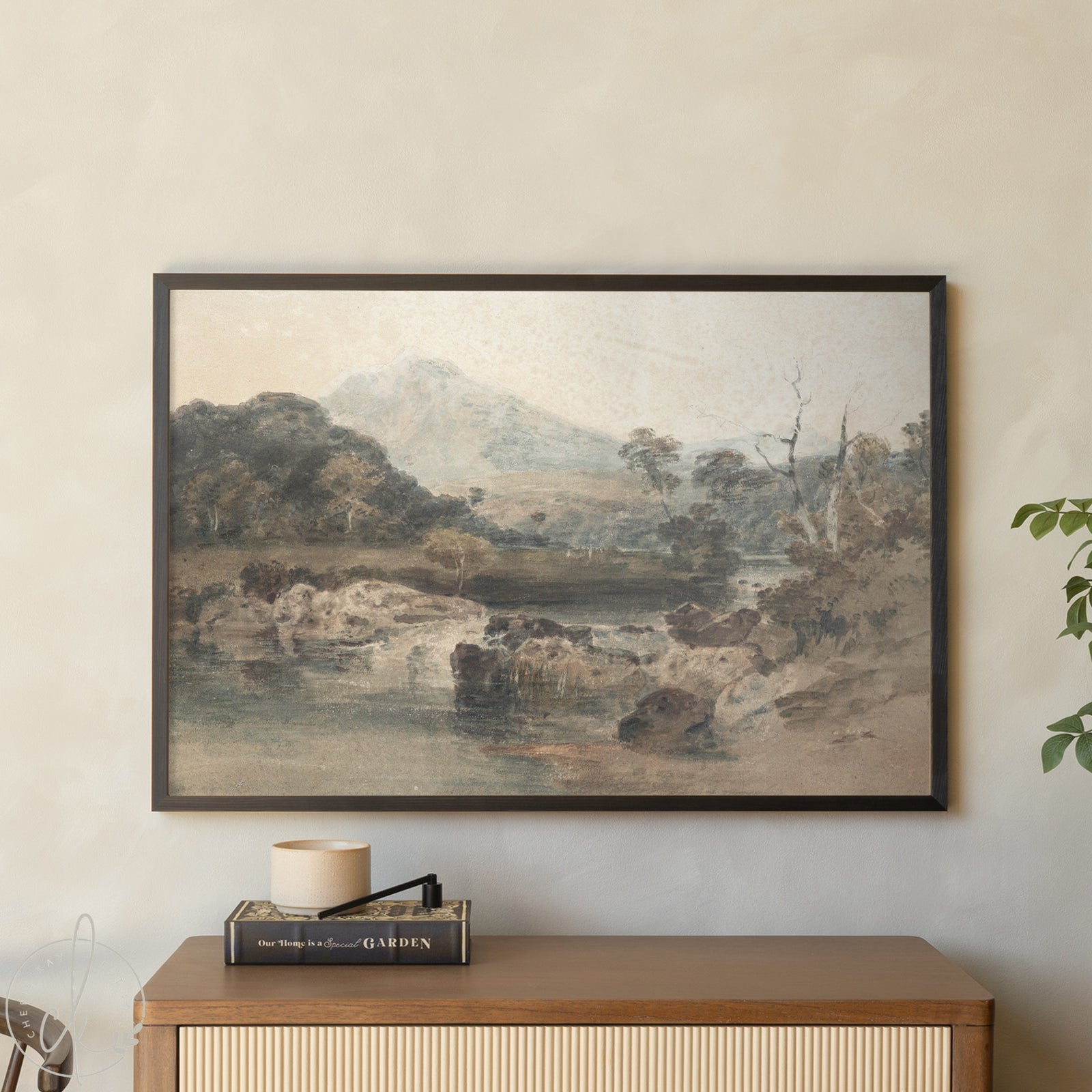 Framed landscape painting on a wall above a wooden cabinet with decorative items.