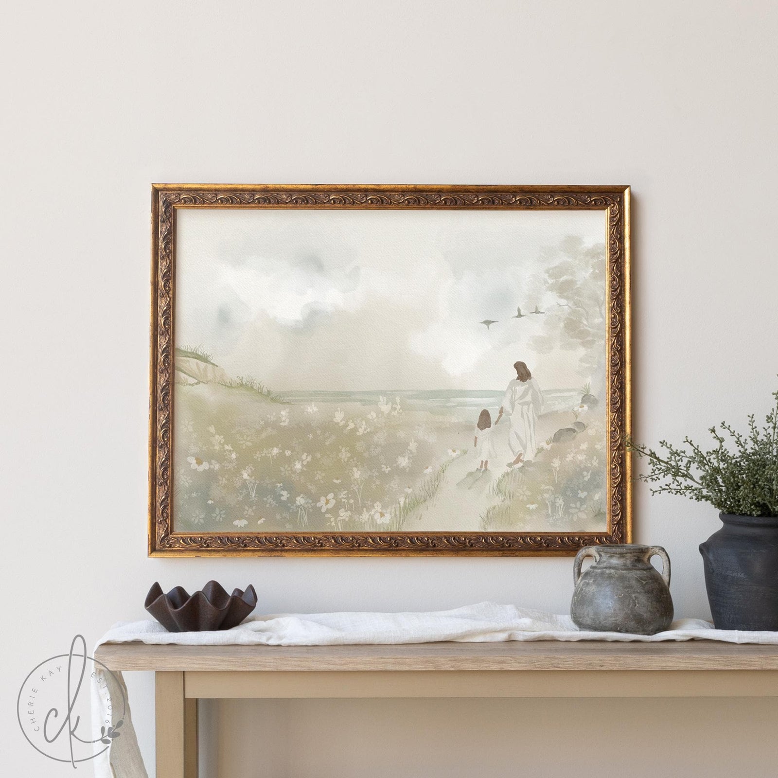 Vintage framed Jesus painting featuring Jesus walking with a child through a pastoral landscape, displayed in an ornate gold frame above a console table with decorative vases.