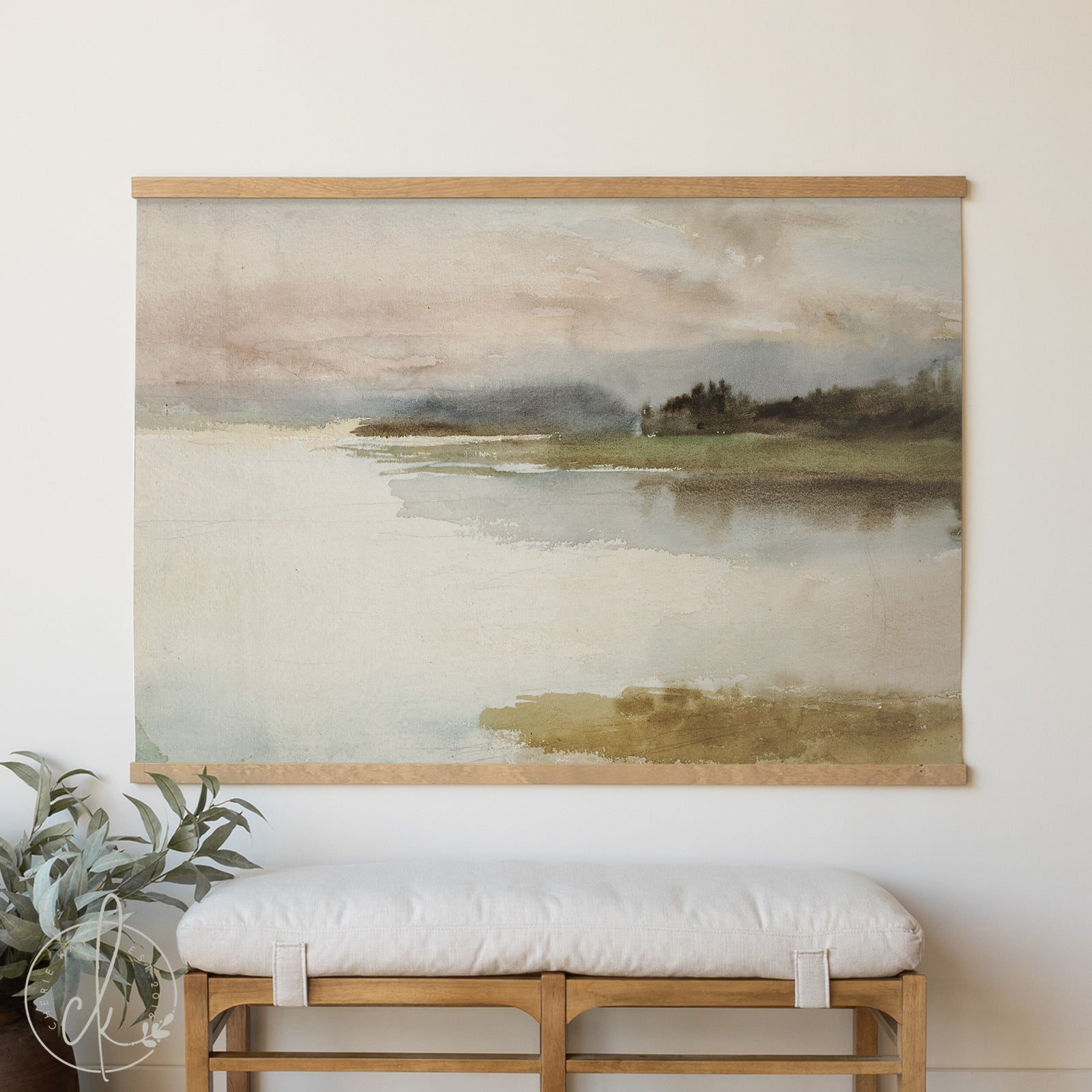 Framed landscape painting on a wall above a wooden bench with a white cushion.