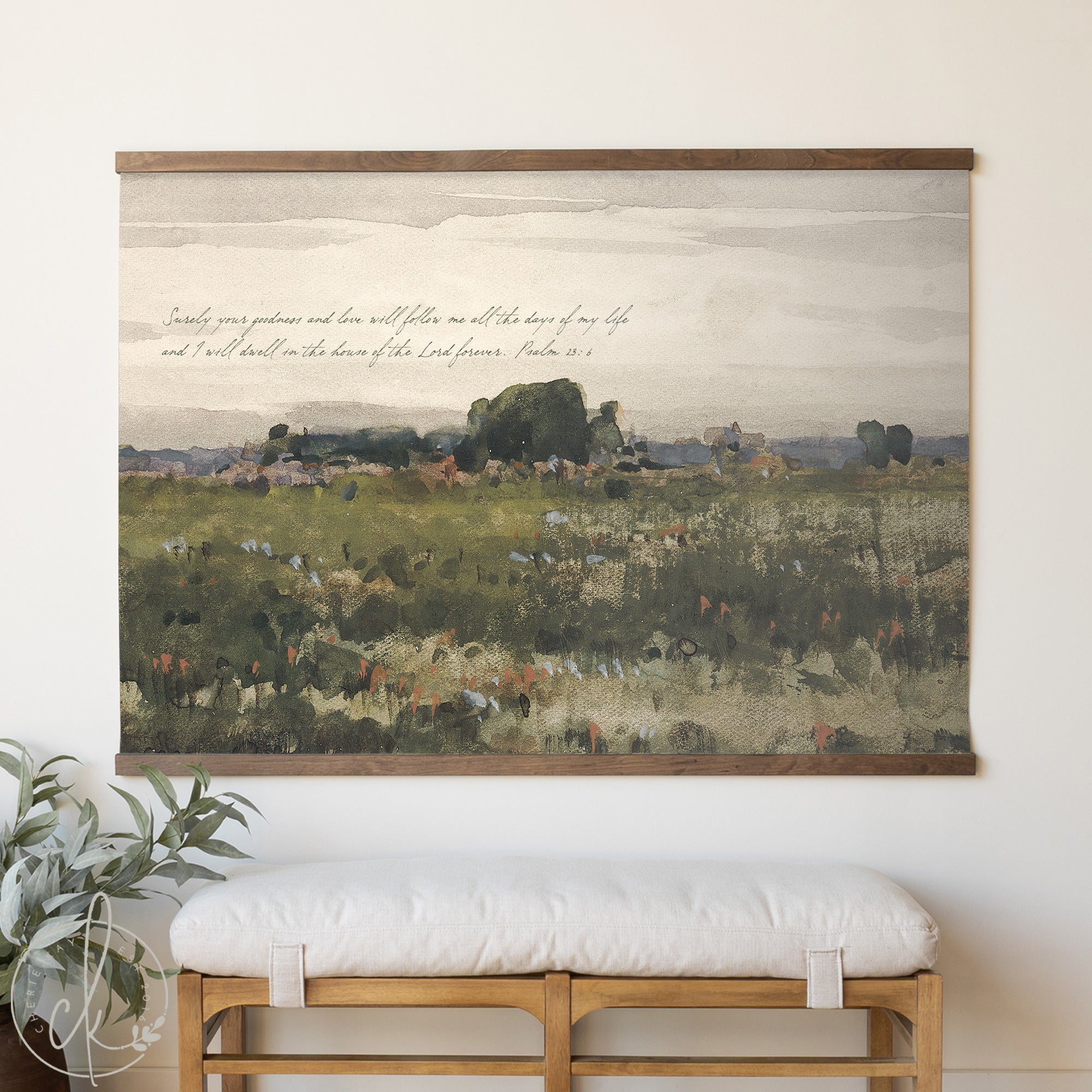 Framed landscape painting with text above a white cushioned bench.