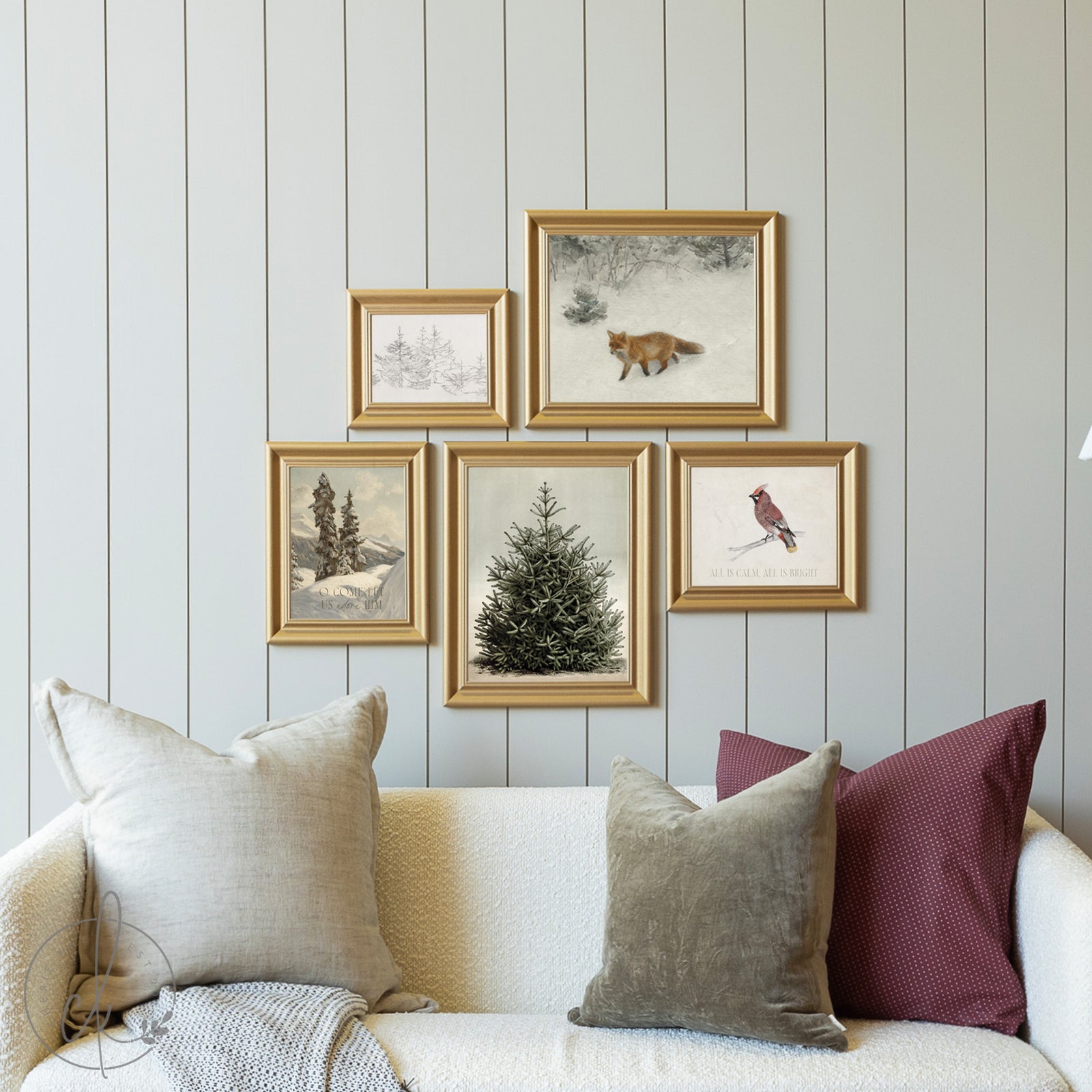 Framed artworks on a wall above a sofa with decorative pillows.