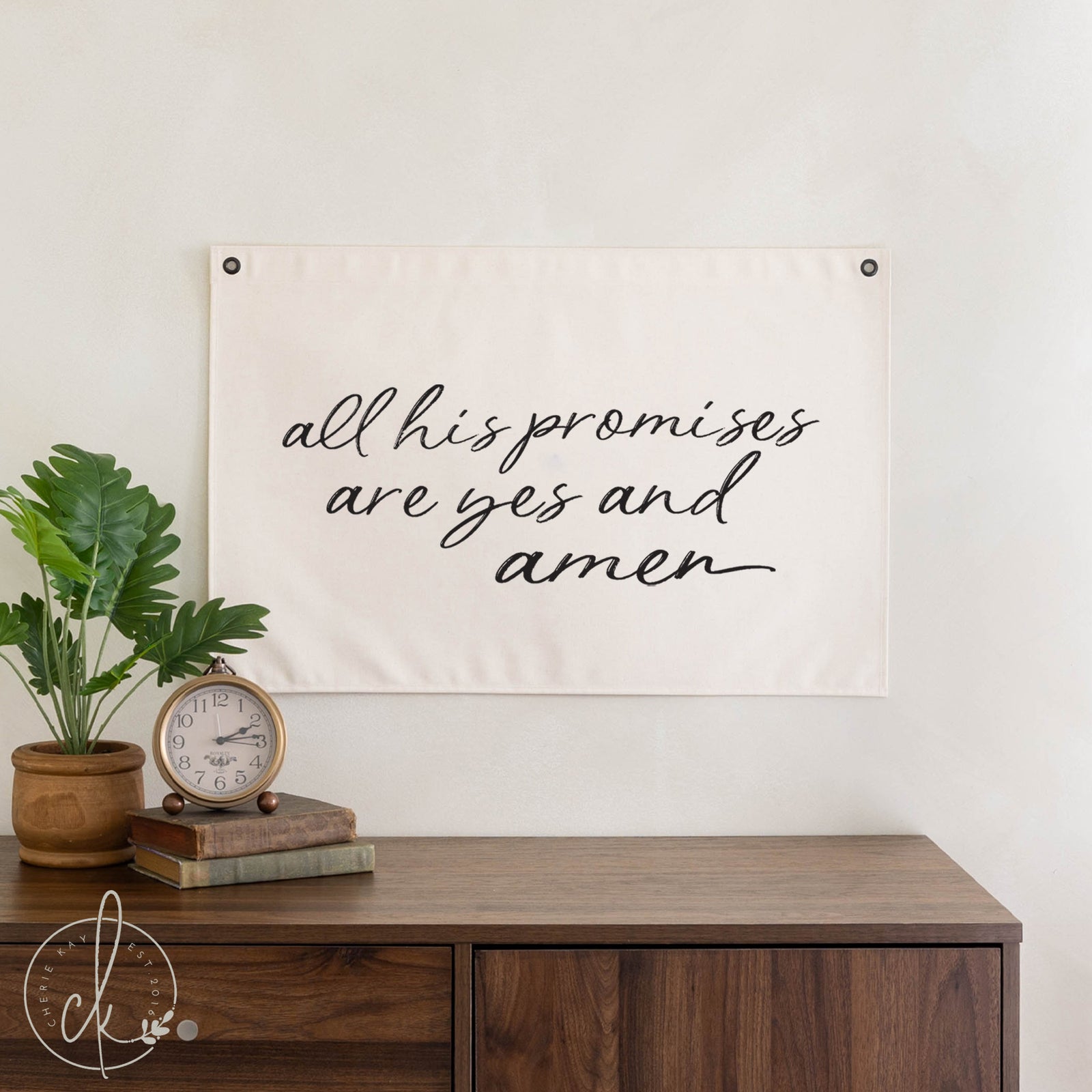 Decorative banner with inspirational quote above a wooden desk with a plant and clock.