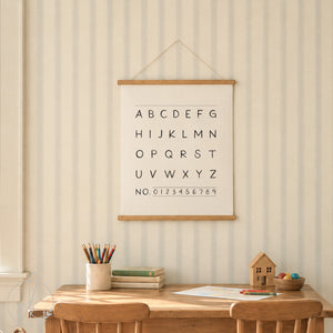 Alphabet and numbers hanging canvas sign with wooden frame and white string, displayed above a children's play table in a sage green playroom.