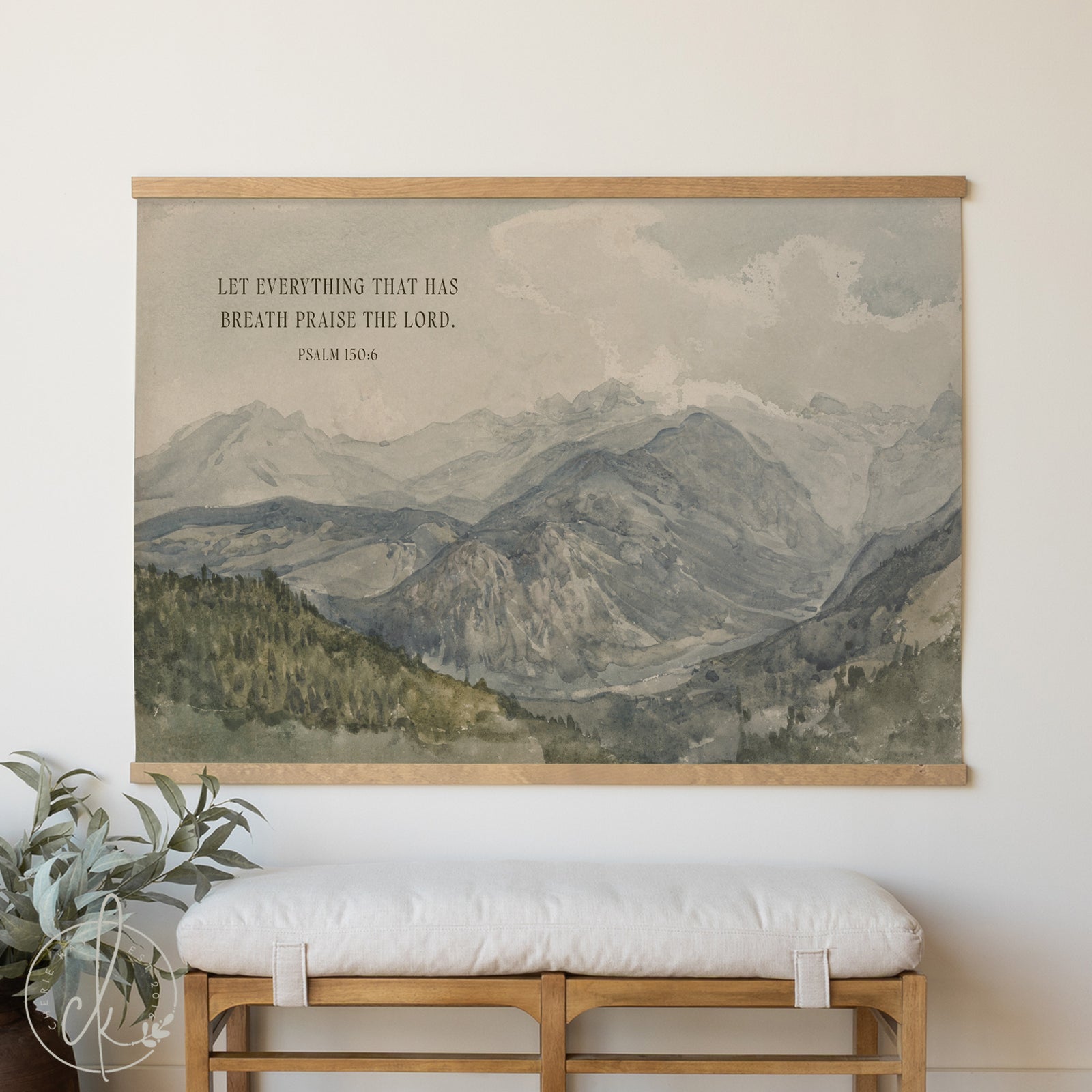 Framed mountain landscape print with inspirational quote on a wall above a bench.