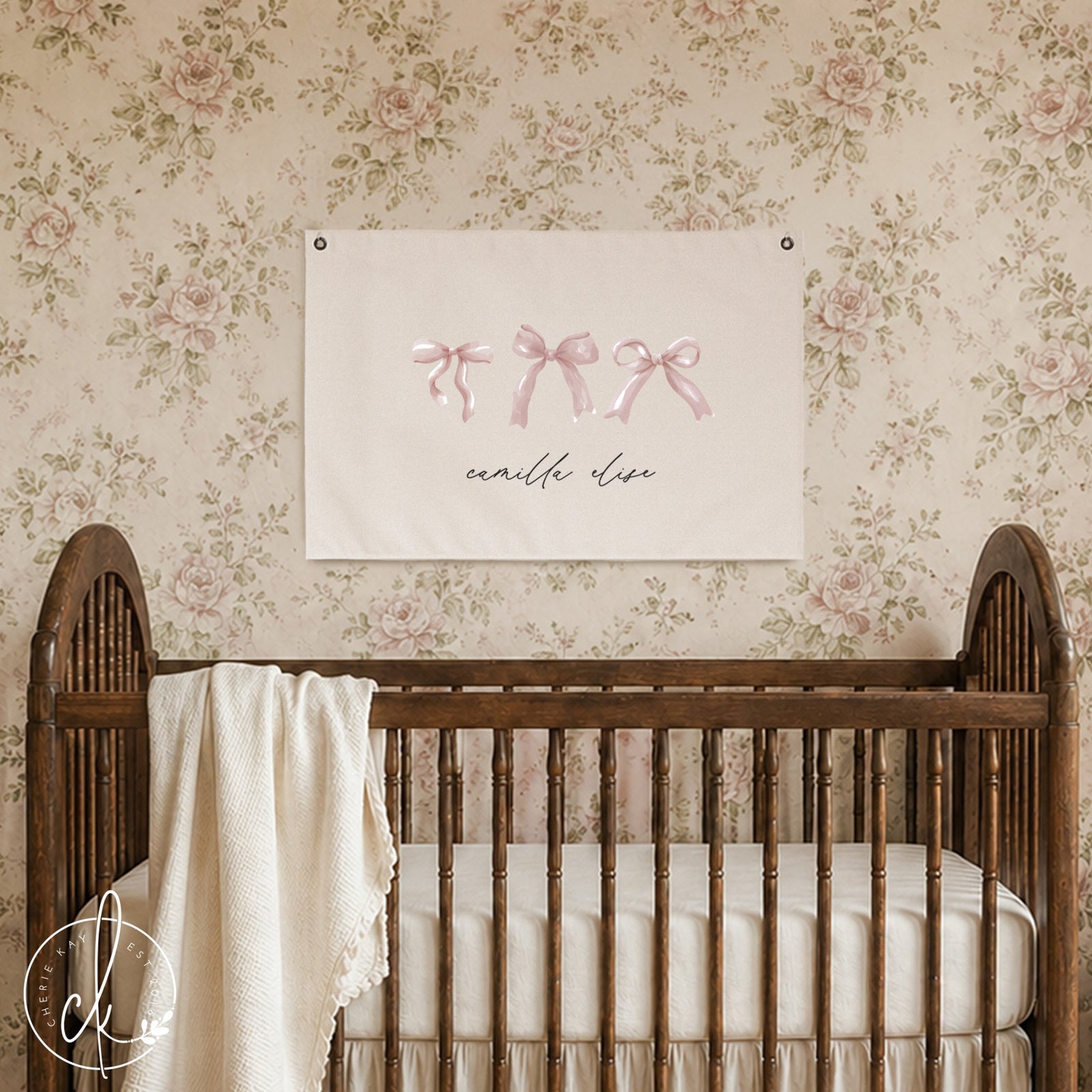 Personalized nursery canvas sign with pink bows and custom name hanging above a baby crib. The delicate pink bow design adds a charming and feminine touch to a girl's room or nursery. Ideal custom wall art for baby girl's room decor.