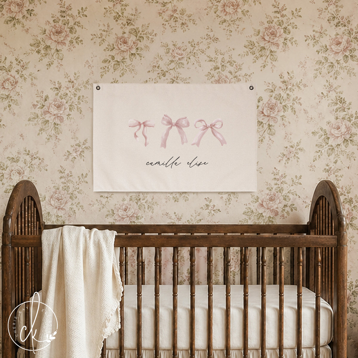 Personalized nursery canvas sign with pink bows and custom name hanging above a baby crib. The delicate pink bow design adds a charming and feminine touch to a girl's room or nursery. Ideal custom wall art for baby girl's room decor.