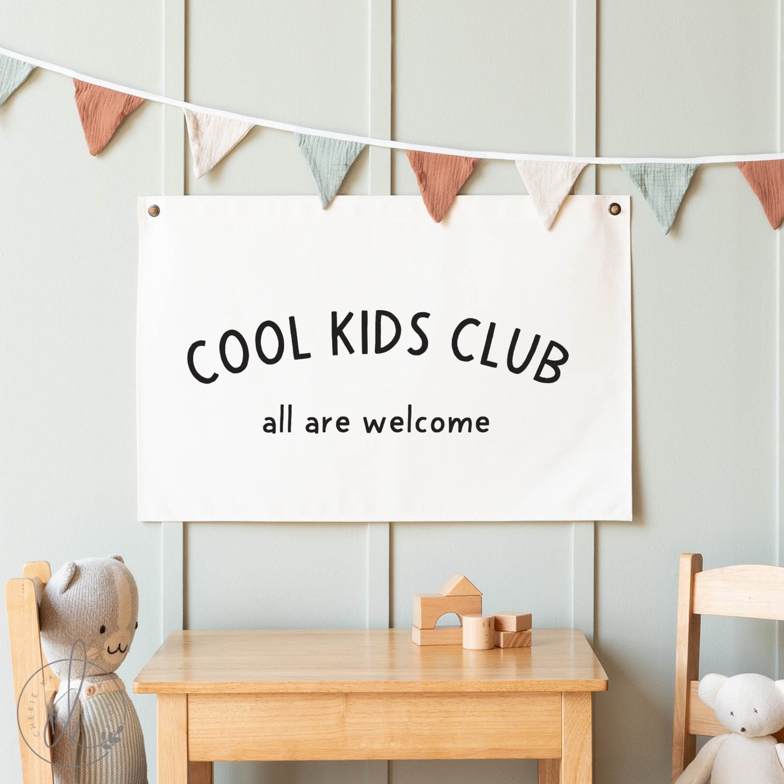 Children's room with 'Cool Kids Club' sign, wooden table, and chairs.