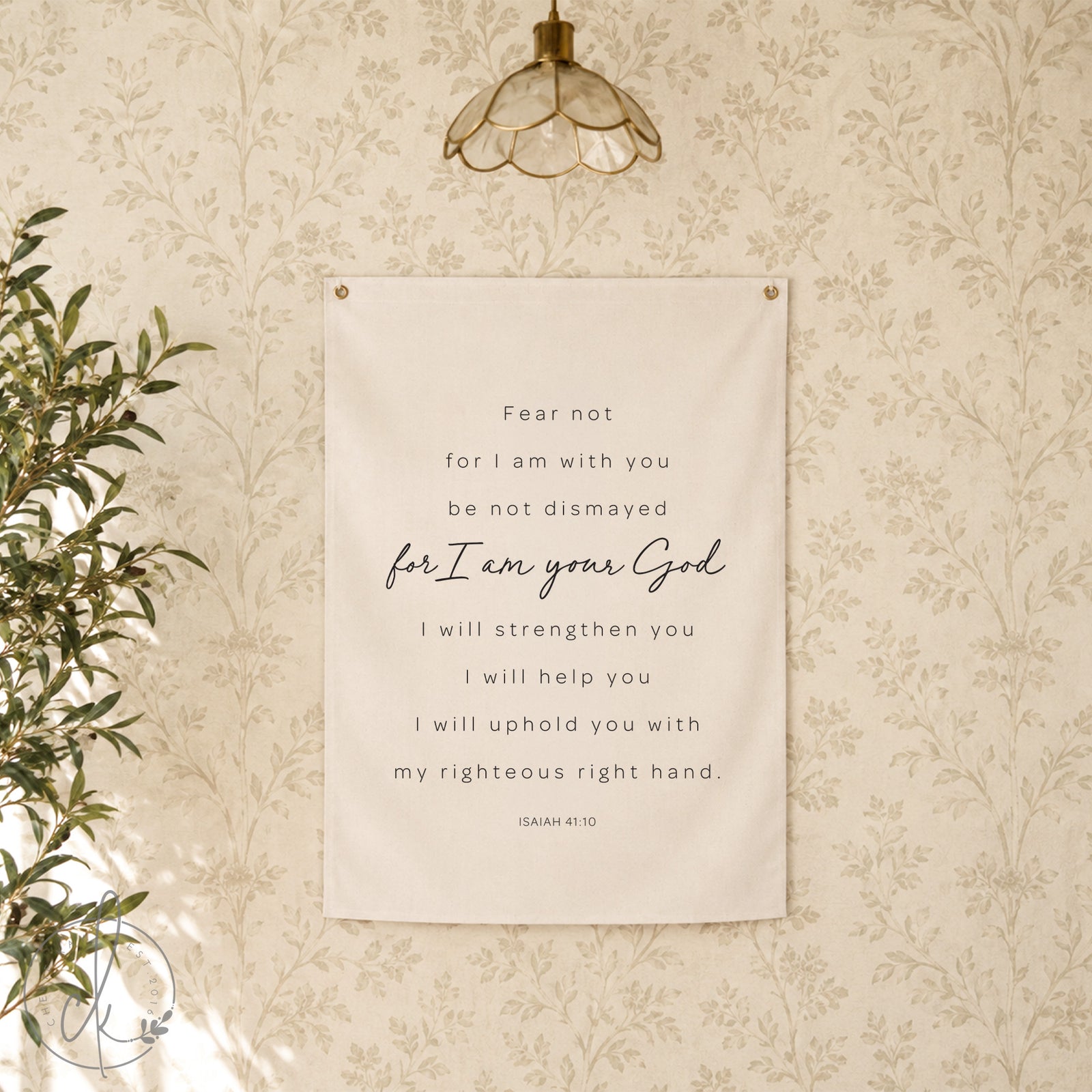 A white canvas wall tapestry with black text that reads "Fear not for I am with you be not dismayed for I am your God I will strengthen you I will help you I will uphold you with my righteous right hand. Isaiah 41:10". 