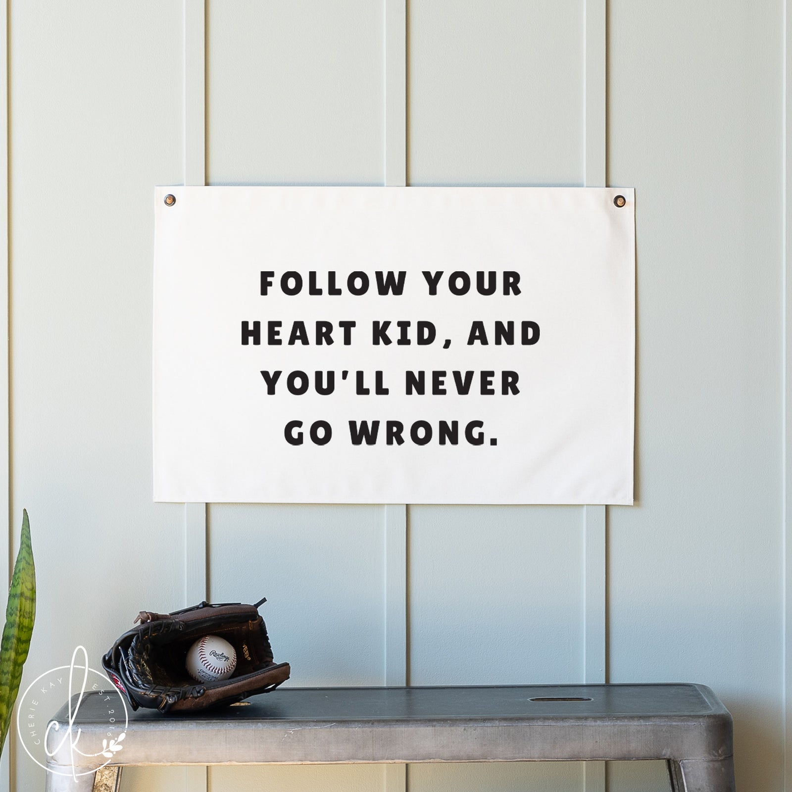 Motivational banner with text on a wall above a shelf with a baseball and glove.