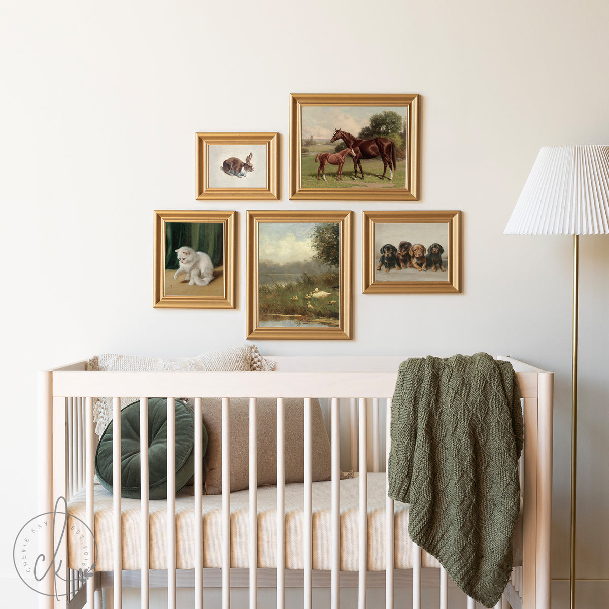 A cozy nursery with a wooden crib and a gallery wall of five gold-framed animal prints, including a horse, rabbit, kitten, puppies, and a countryside scene, creating a warm, inviting atmosphere.