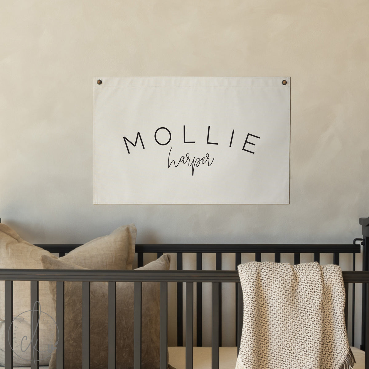 Nursery with a banner displaying &#39;MOLLIE harper&#39; above a crib.
