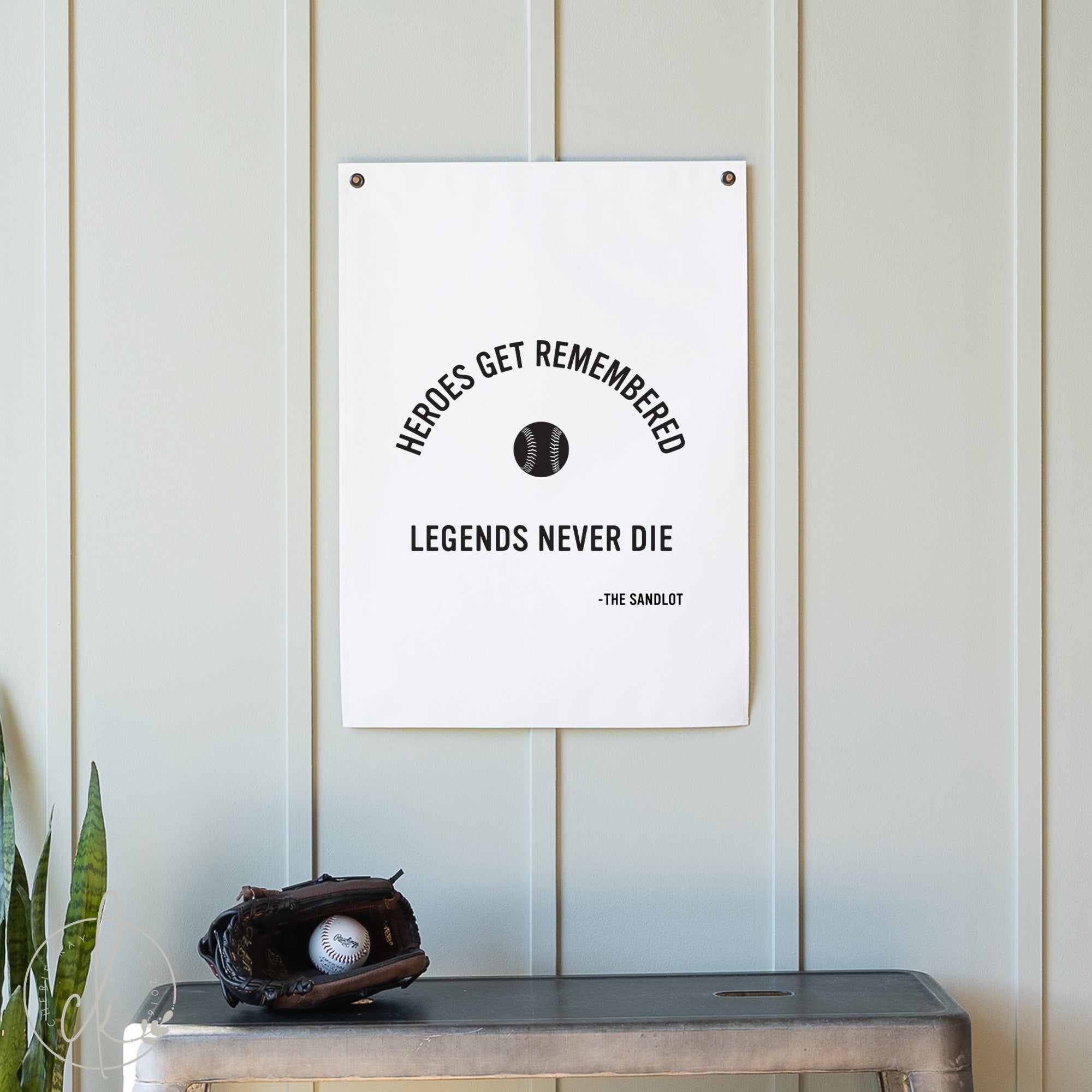 Poster with 'Heroes get remembered, legends never die' quote on a wall with a baseball glove and ball below.