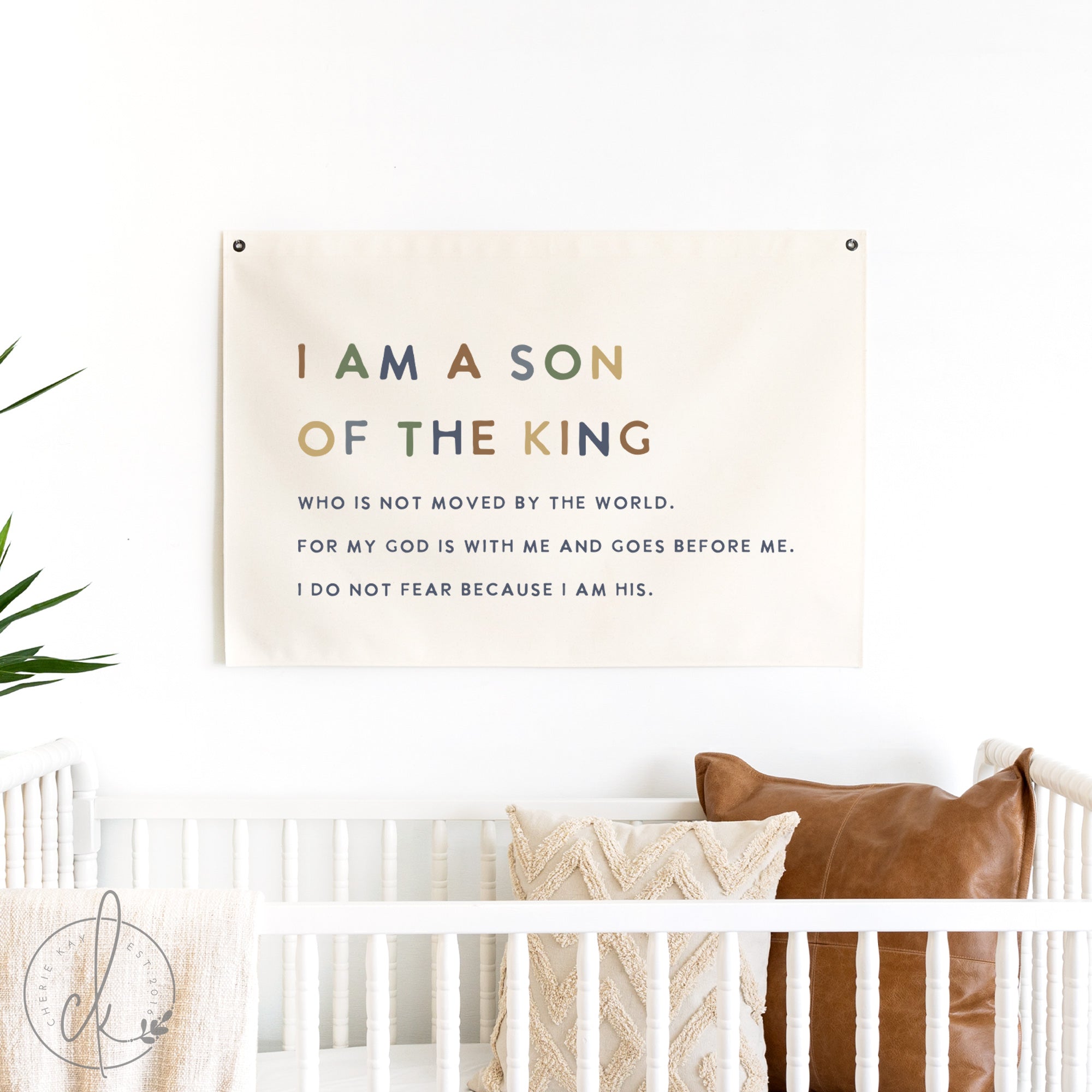 Decorative banner with inspirational quote above a crib in a nursery.
