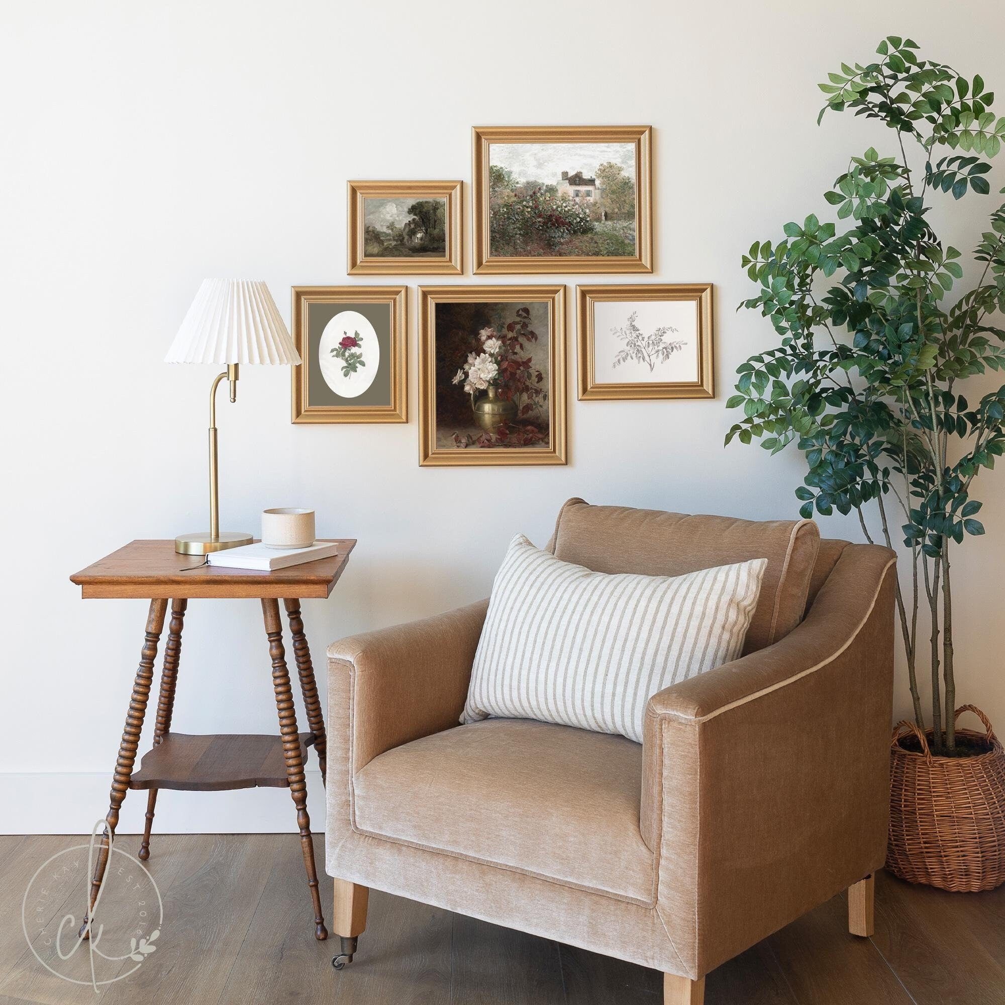 Cozy living room corner featuring a beige armchair with a striped cushion, a wooden side table with a lamp, and a curated gallery wall of vintage-style gold framed art prints depicting floral and scenic designs, complemented by a lush potted plant.