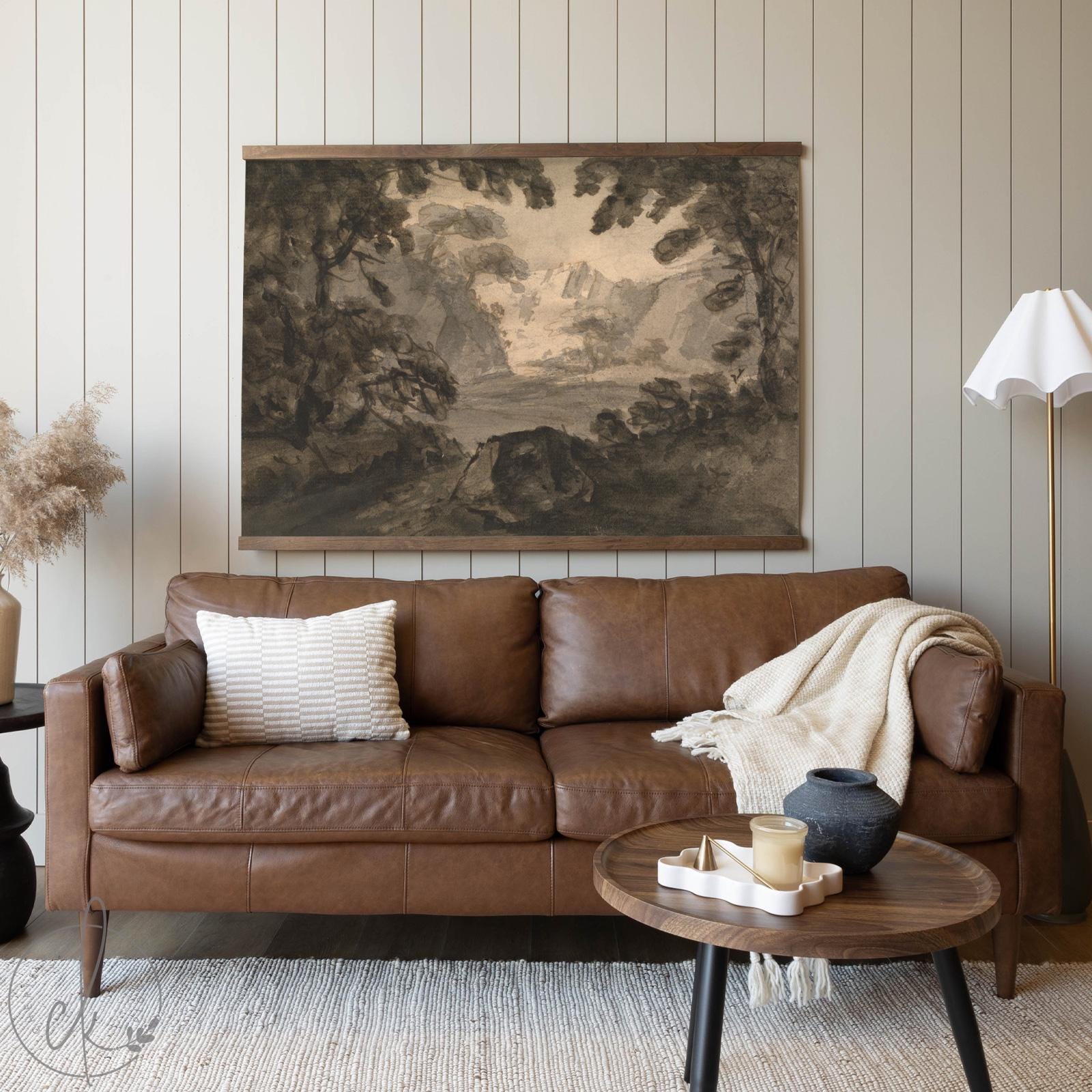 Large tapestry landscape art featuring a serene mountain valley scene with rustic trees, hung as wall decor in a cozy living space.