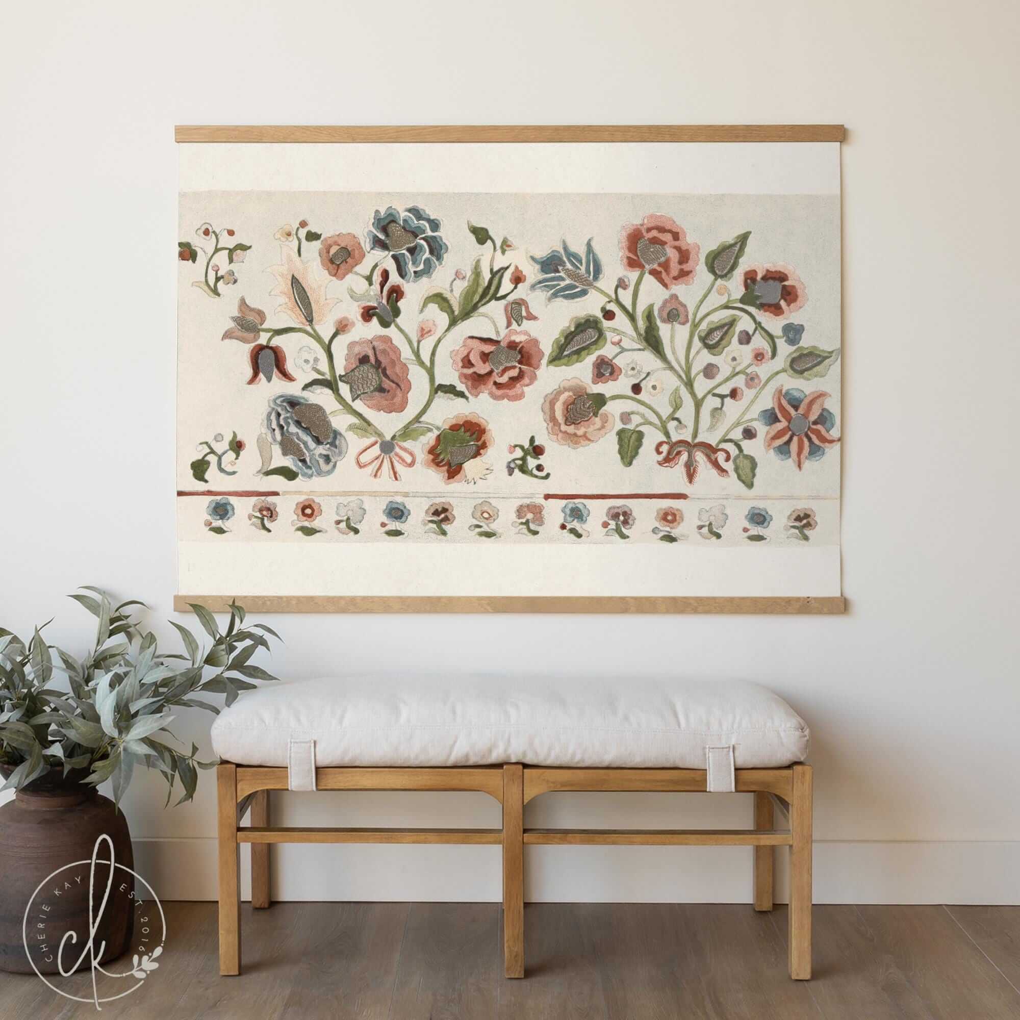 Vintage botanical tapestry with antique floral design hanging above a wooden bench in a cozy, neutral-toned room.