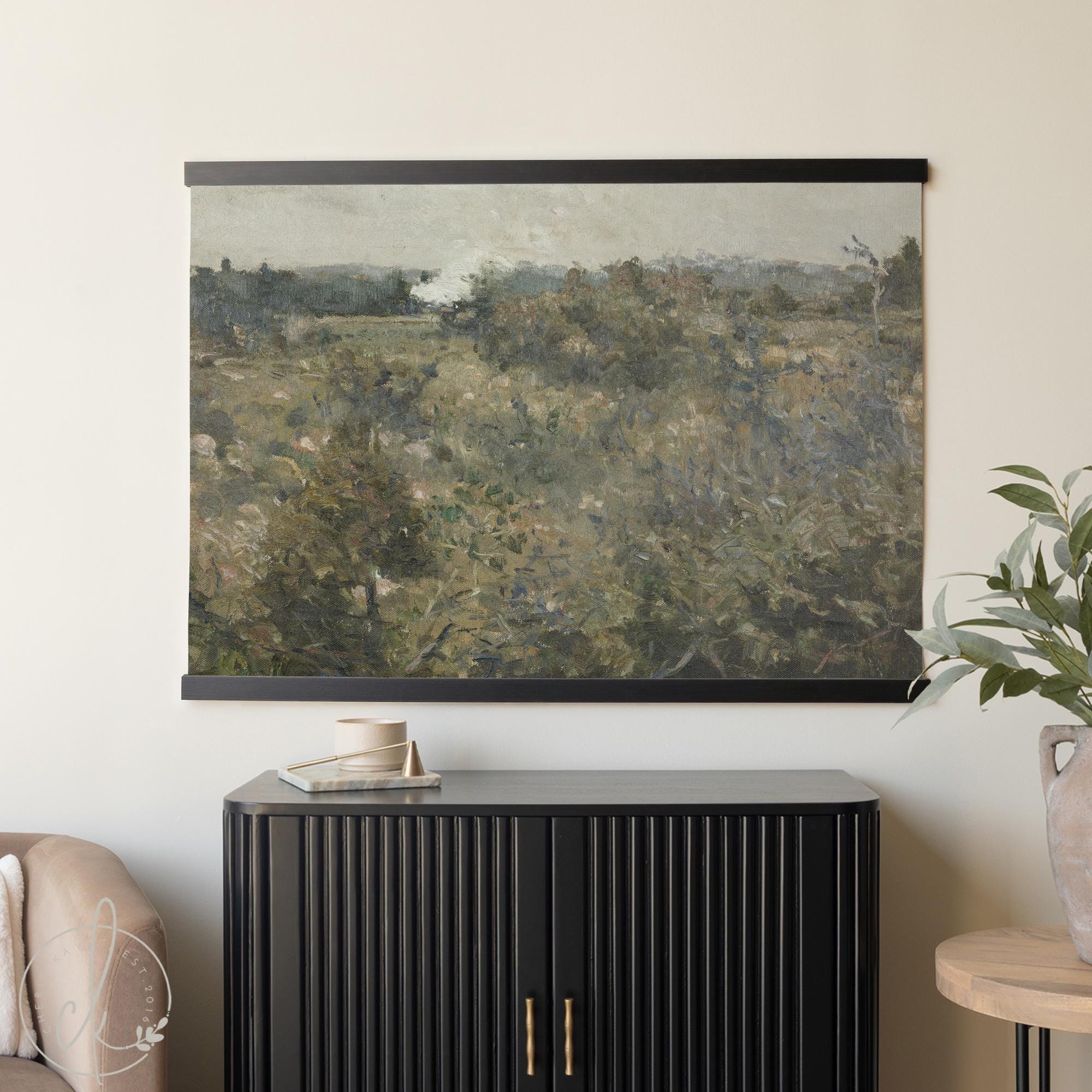 Large wall art tapestry featuring a vintage moody botanical field landscape, framed with handcrafted wood hangers.