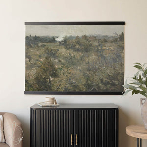 Large wall art tapestry featuring a vintage moody botanical field landscape, framed with handcrafted wood hangers.