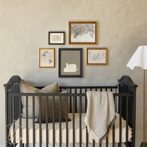 5-piece nursery wall art set of vintage animal & botanical prints framed in ornate gold and black, styled above a crib.